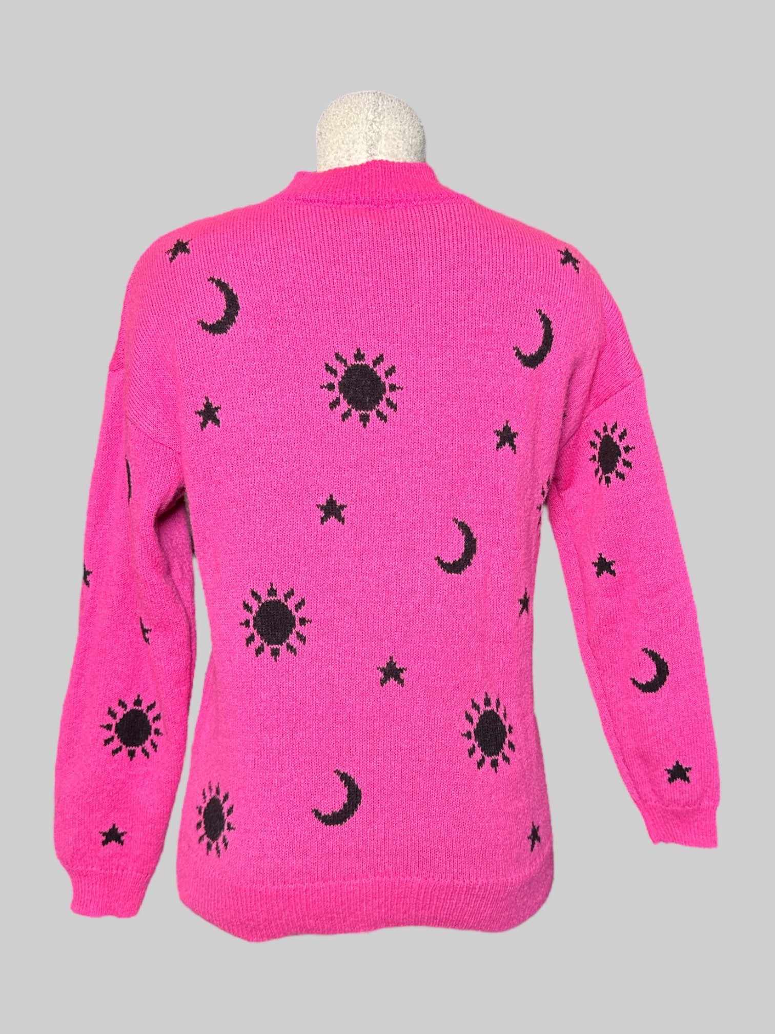 M No Boundaries pink knit long sleeve sweater with black moons, stars, and suns