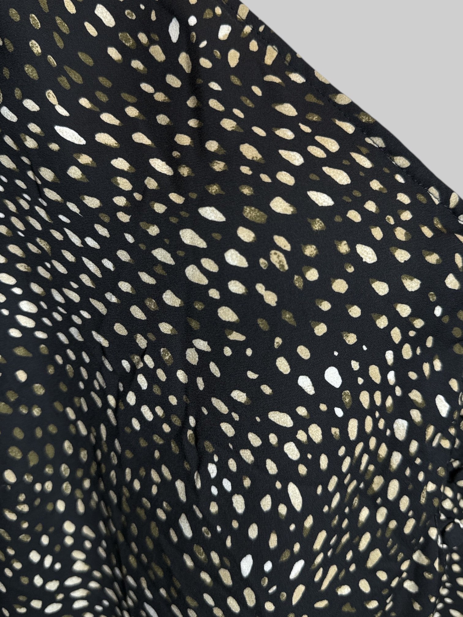 3X Torrid black sleeveless top with faux buttons, green, white, and tan spotted front panel, and black pleated back panel