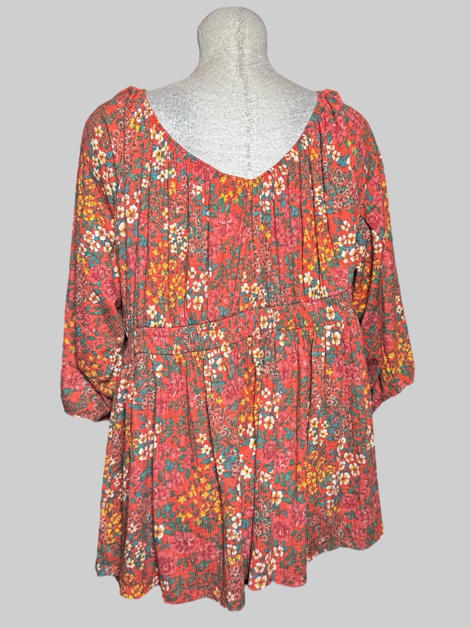 3X Torrid orangey pink top with multicolor florals, a shirred waist, and balloon sleeves