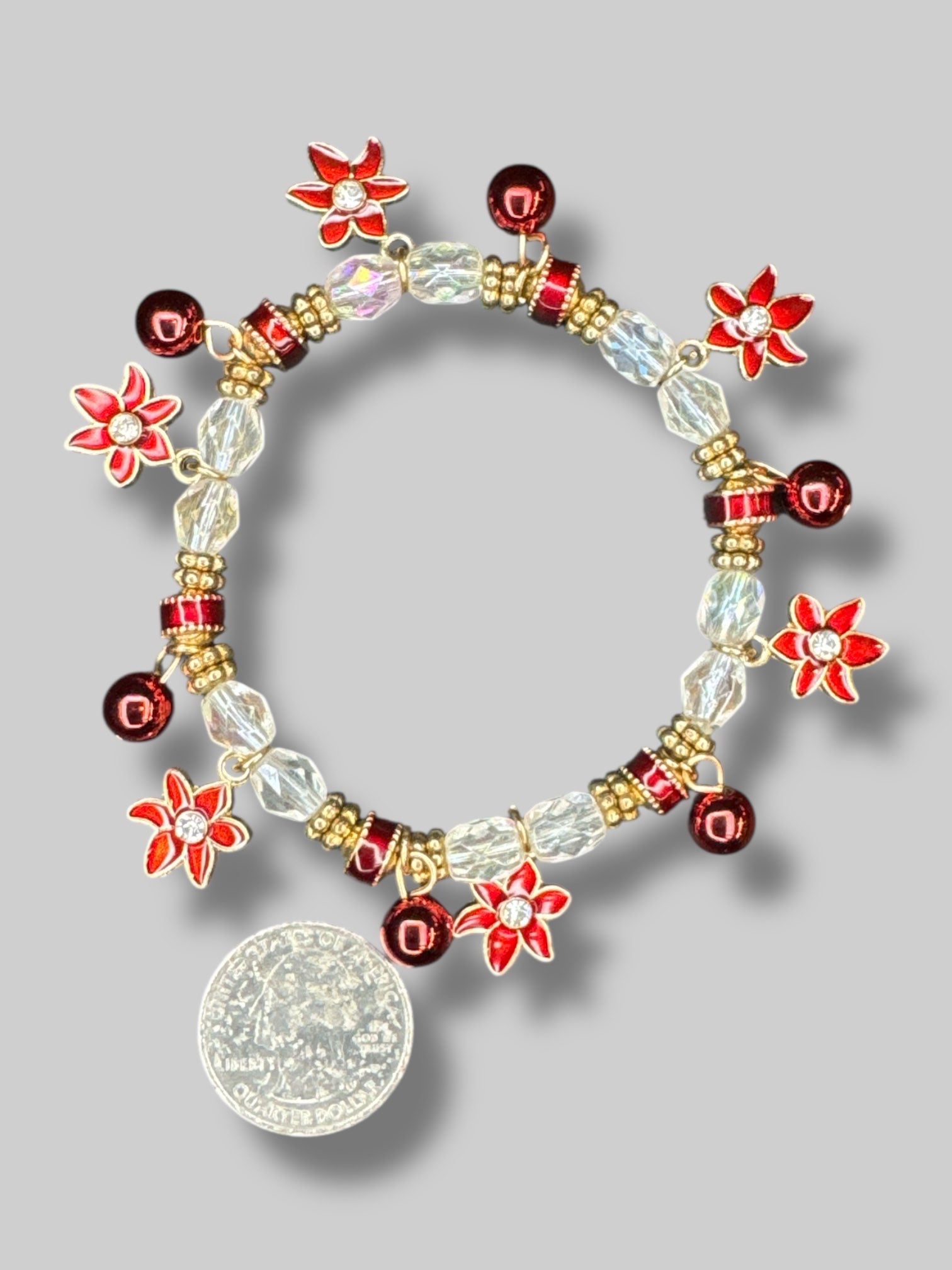 White, red, and gold color beaded bracelet with poinsettia charms
