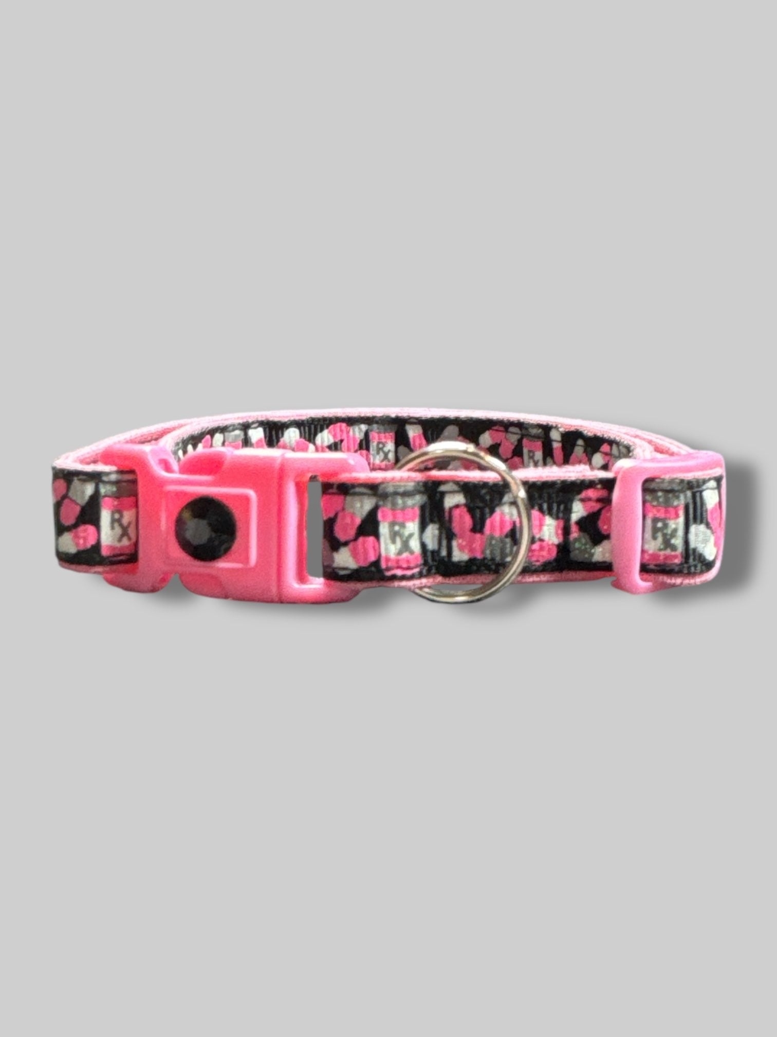 Pink, black, white, and gray cat collar with pill bottles and pills. 15’ long unclasped