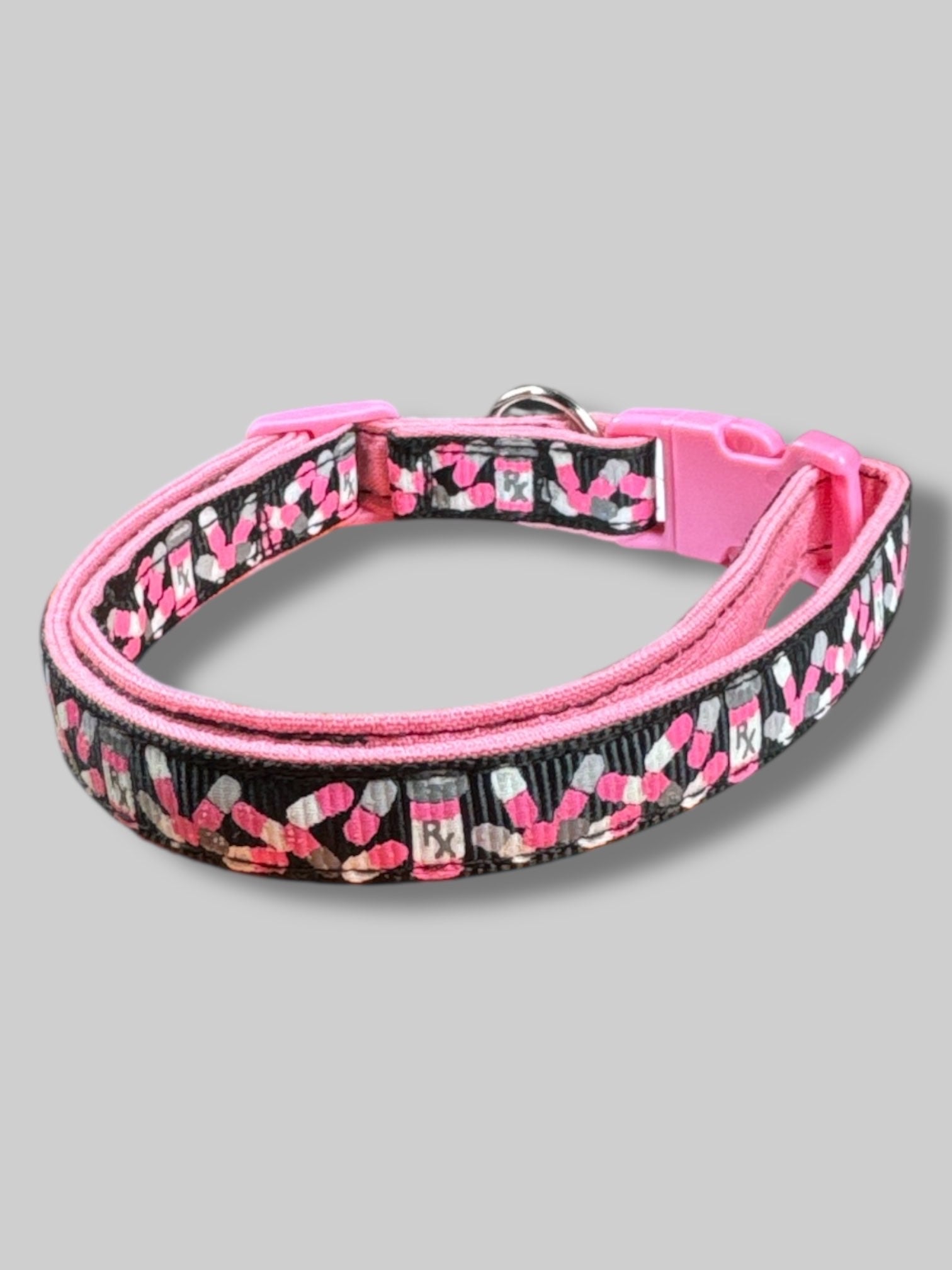 Pink, black, white, and gray cat collar with pill bottles and pills. 15’ long unclasped