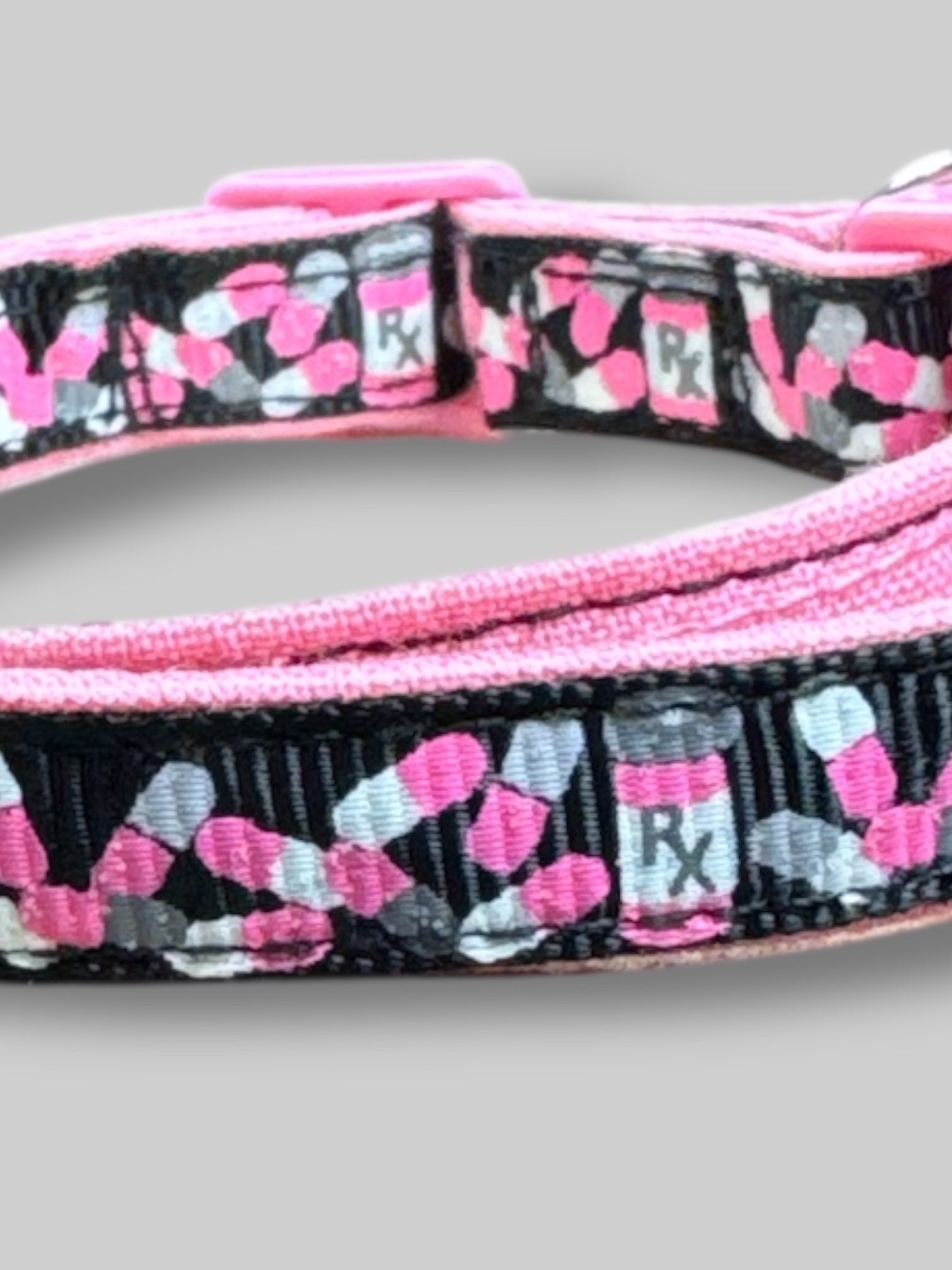 Pink, black, white, and gray cat collar with pill bottles and pills. 15’ long unclasped