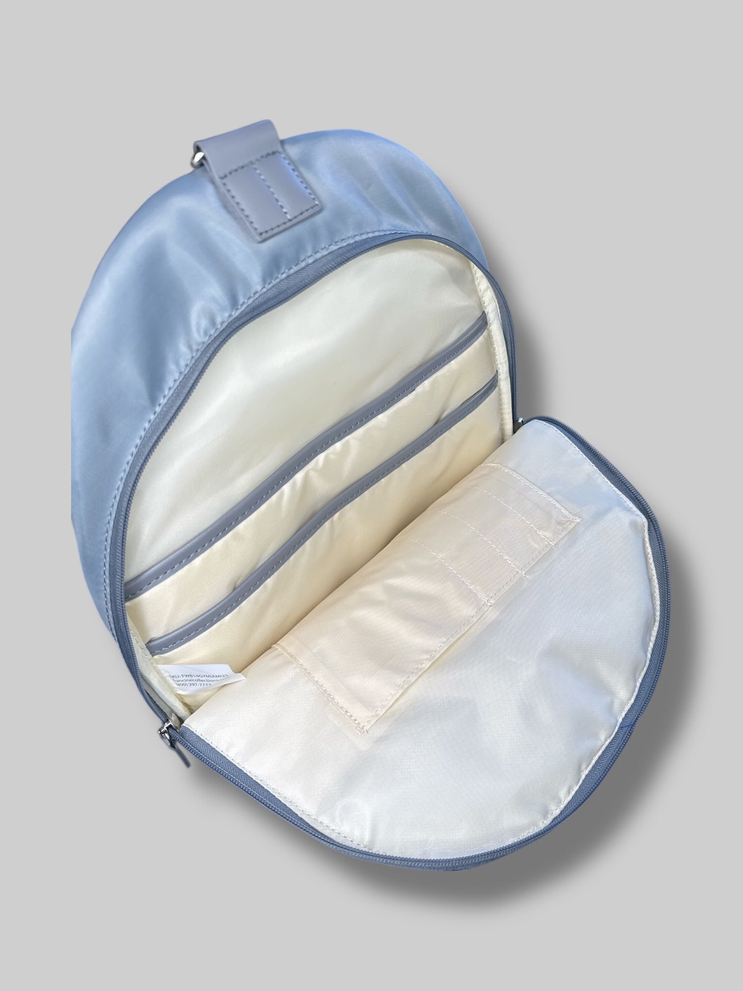 Francine Collections Silver lightly padded laptop backpack with one adjustable strap and many zipper pockets