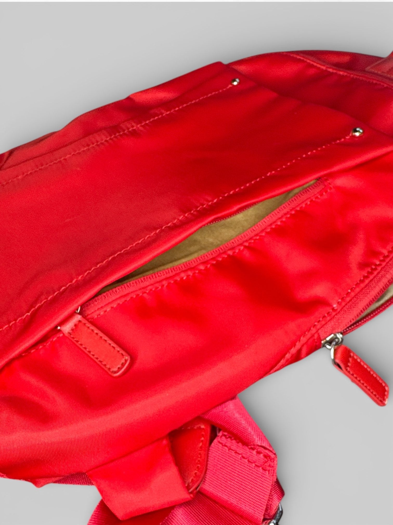 Francine Collections Red lightly padded laptop backpack with one adjustable strap and many zipper pockets