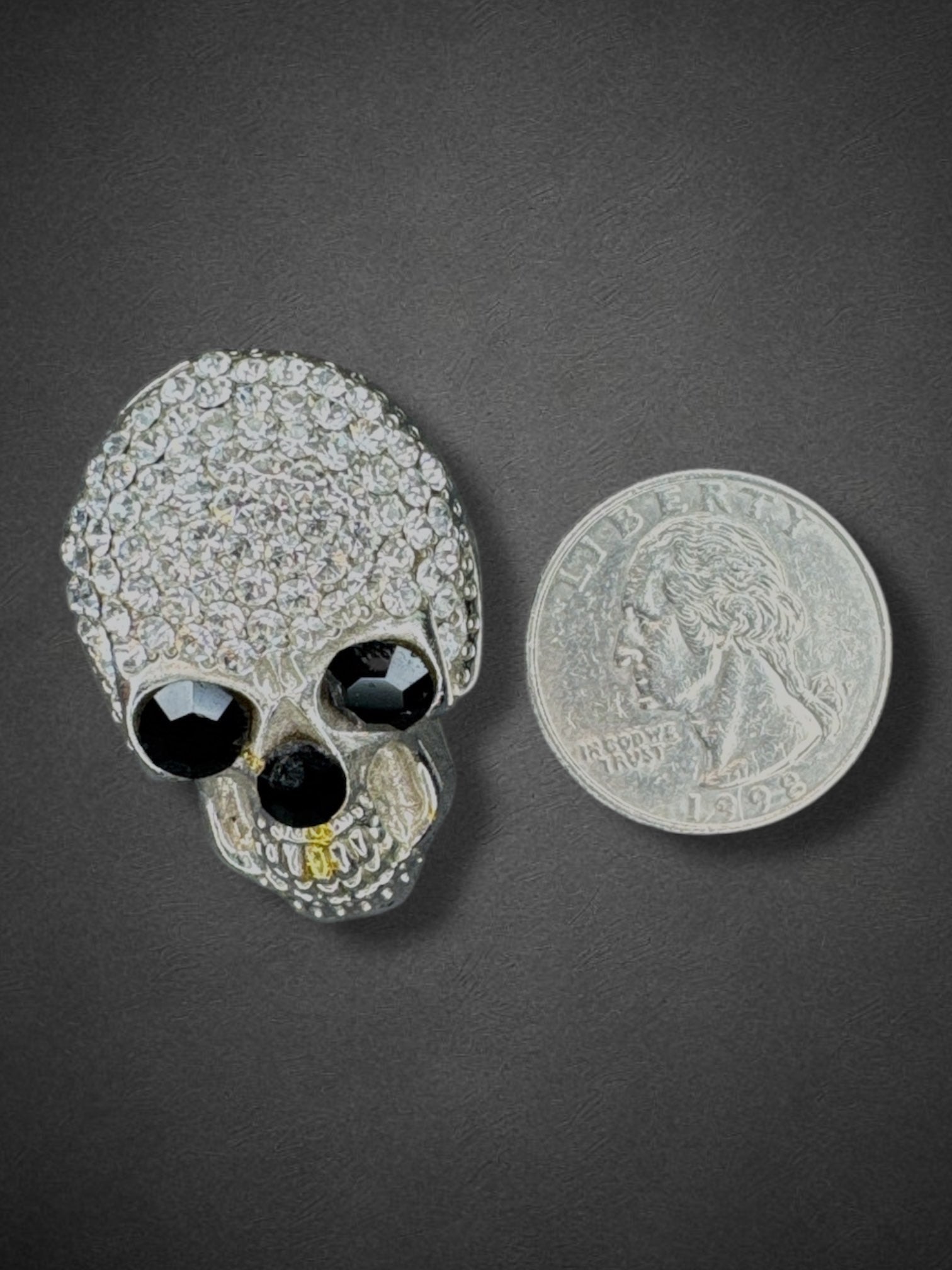 Silver tone skull brooch with black eyes and nose and some yellow