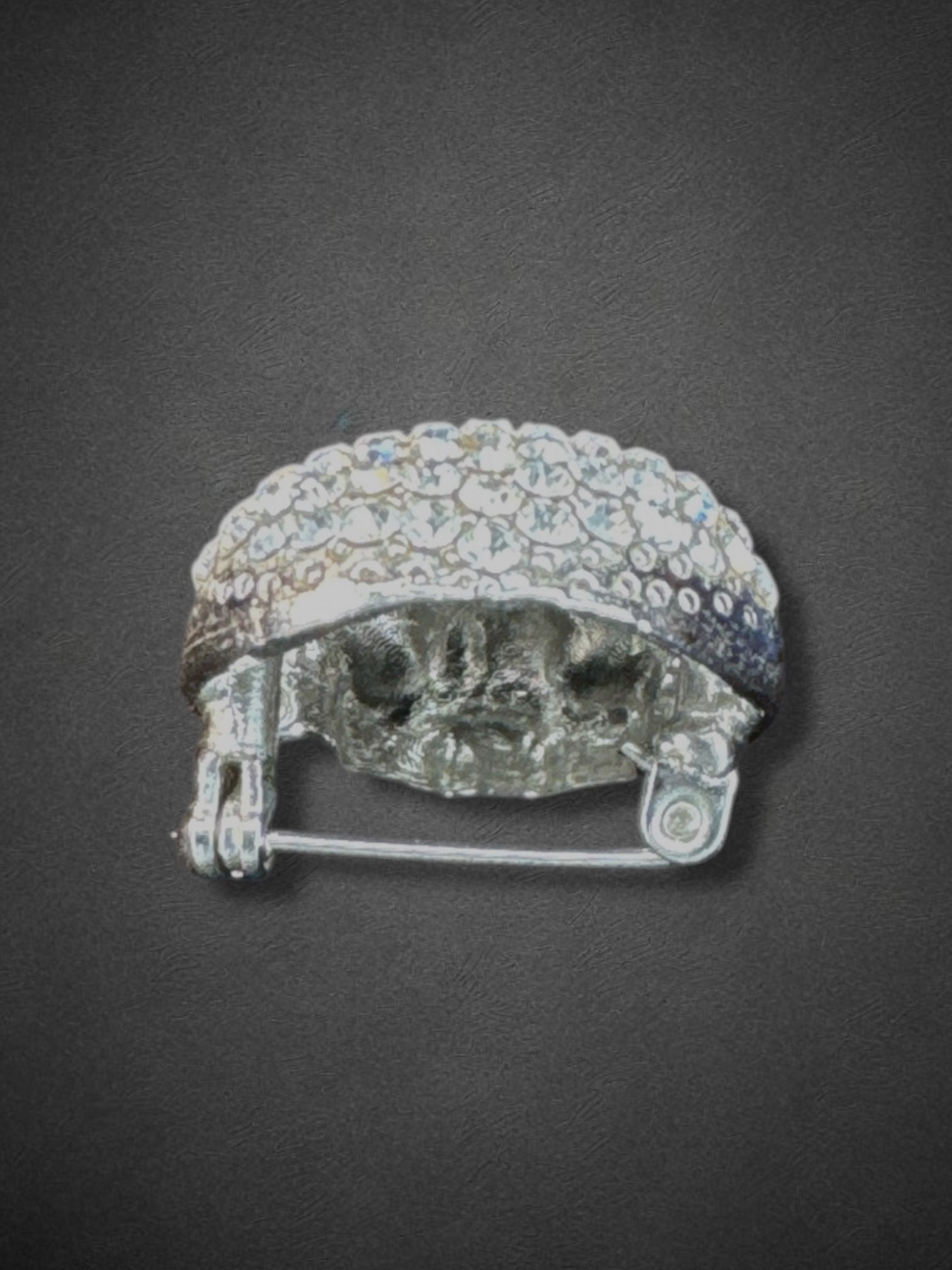 Silver tone skull brooch with black eyes and nose and some yellow