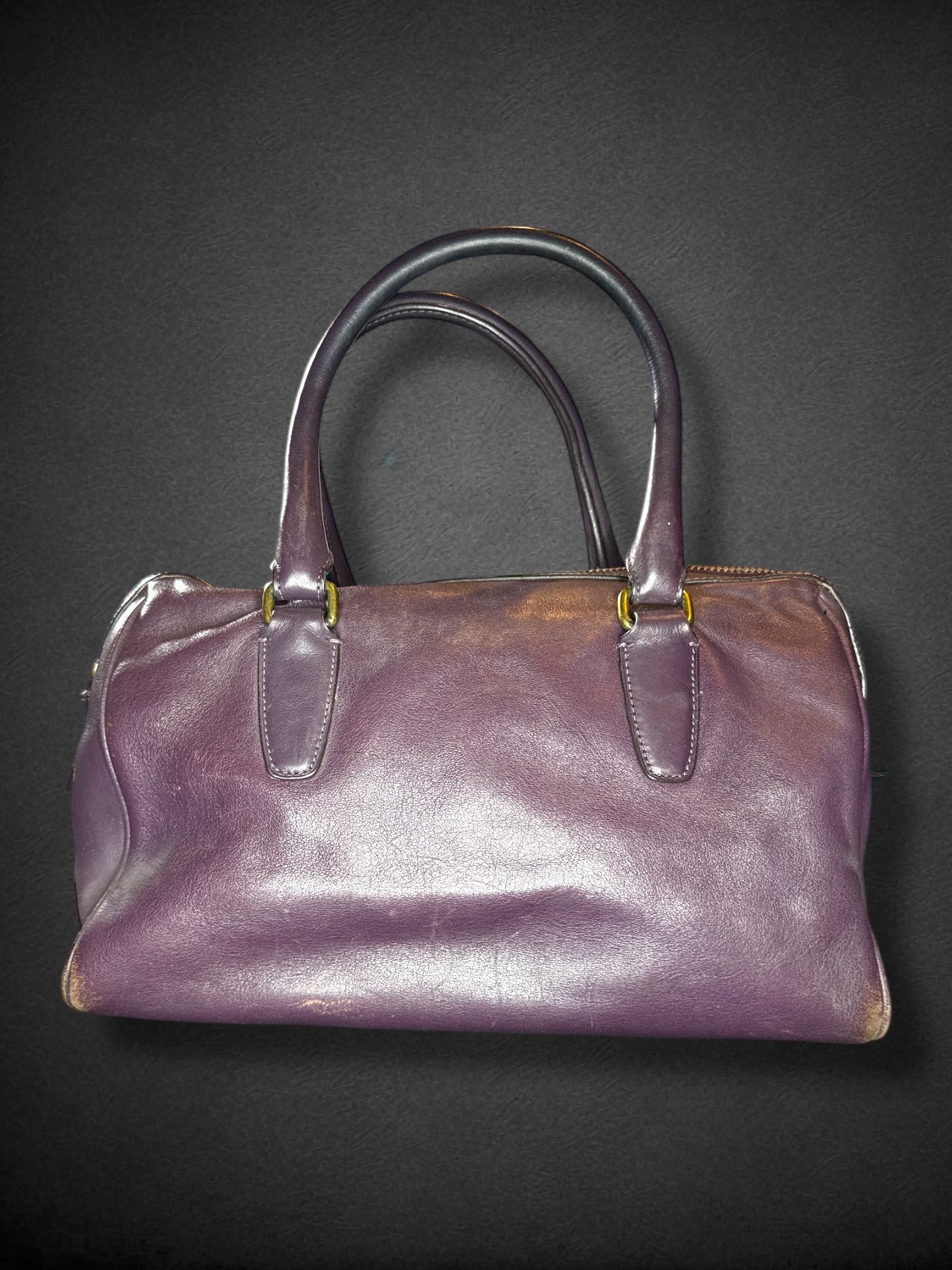 Coach purple leather purse with handles, bronze studding, and large leather tassels on front