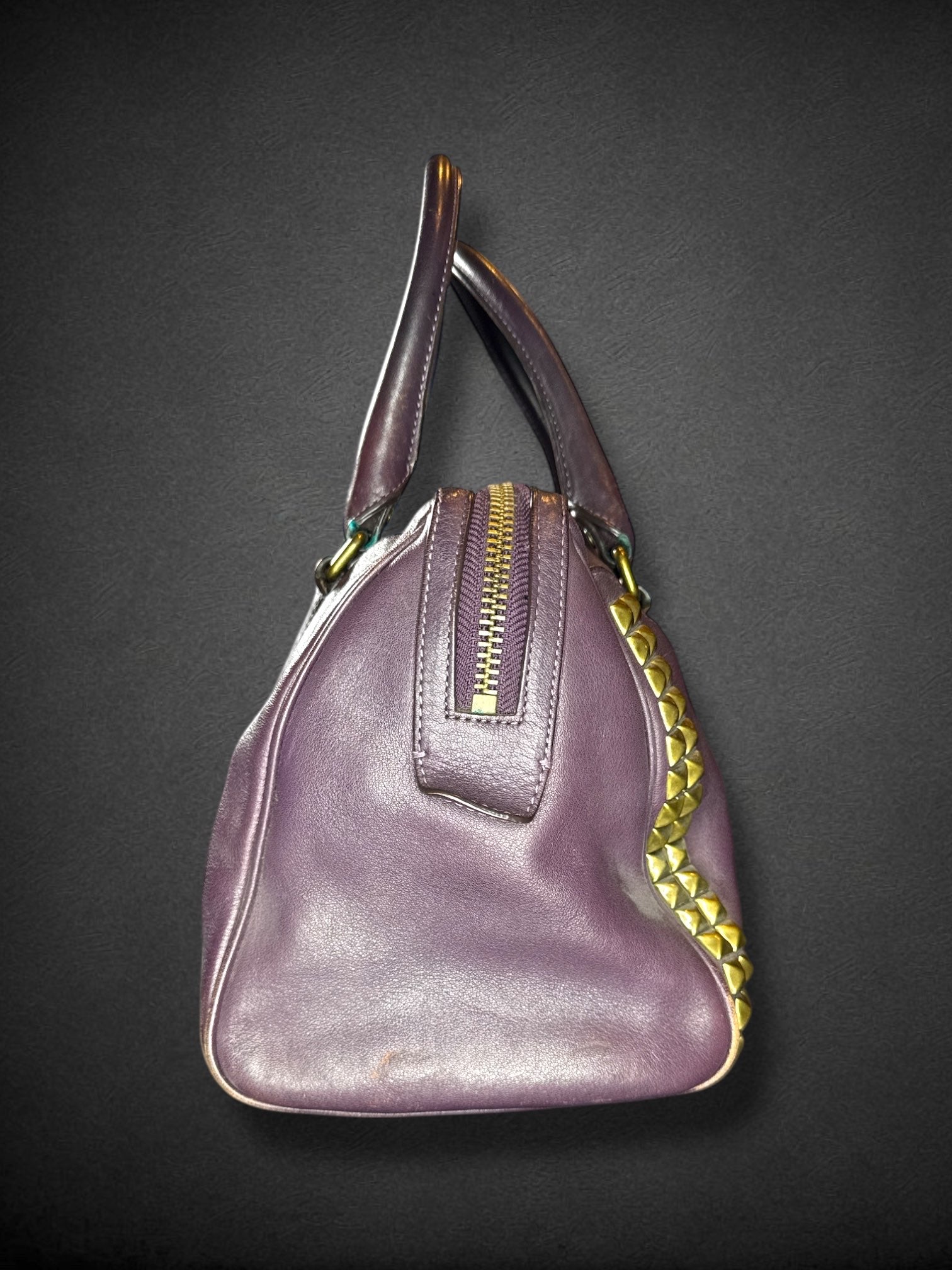 Coach purple leather purse with handles, bronze studding, and large leather tassels on front