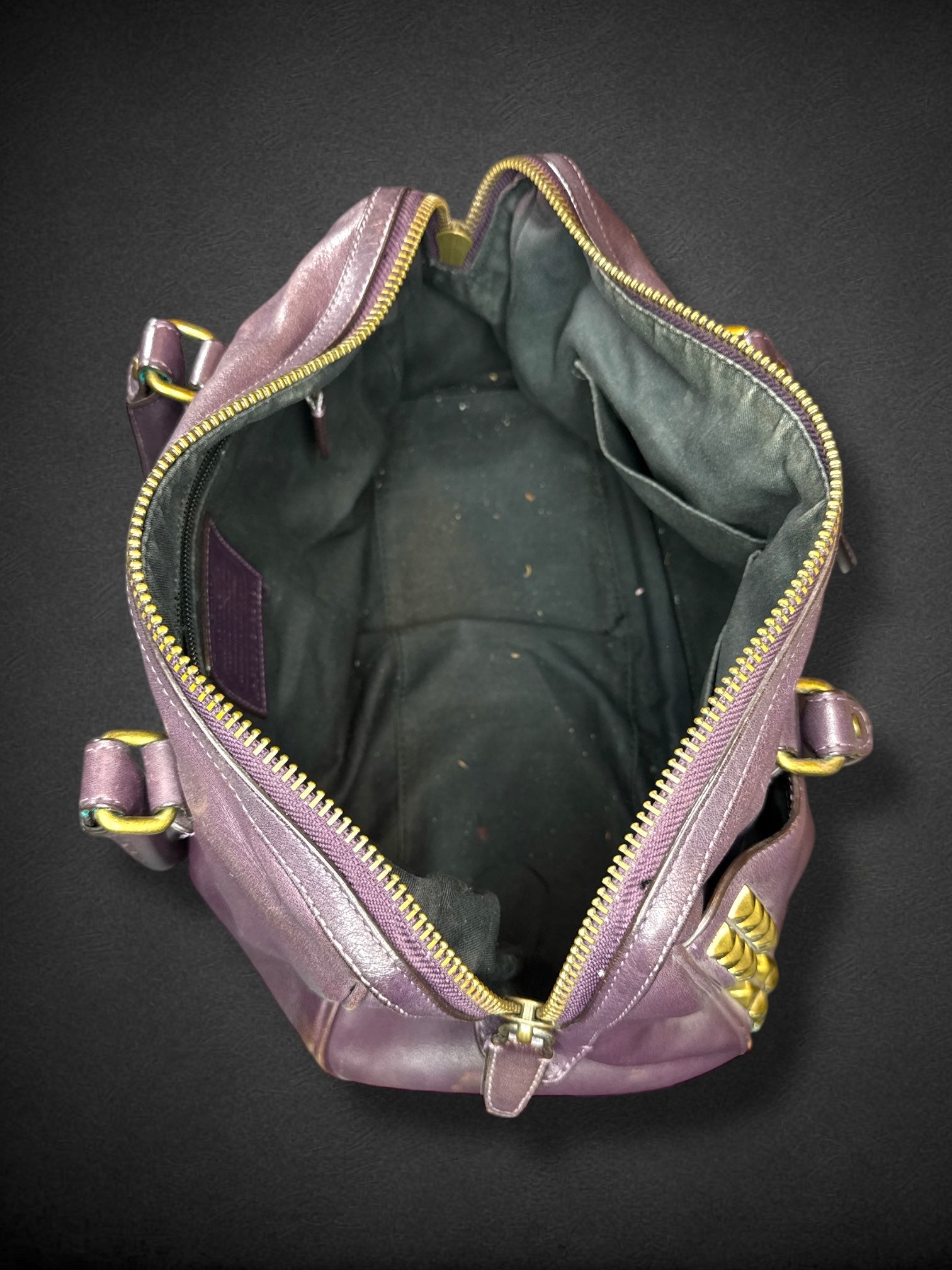 Coach purple leather purse with handles, bronze studding, and large leather tassels on front