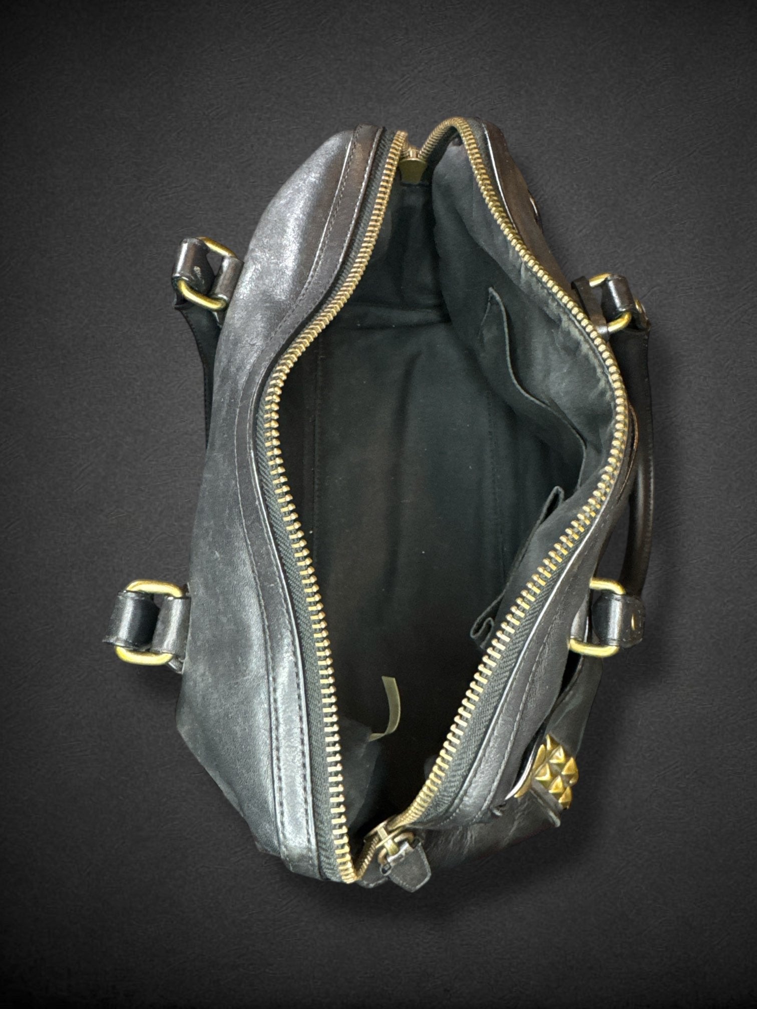 Coach black leather purse with handles, bronze studding, and large leather tassels on front