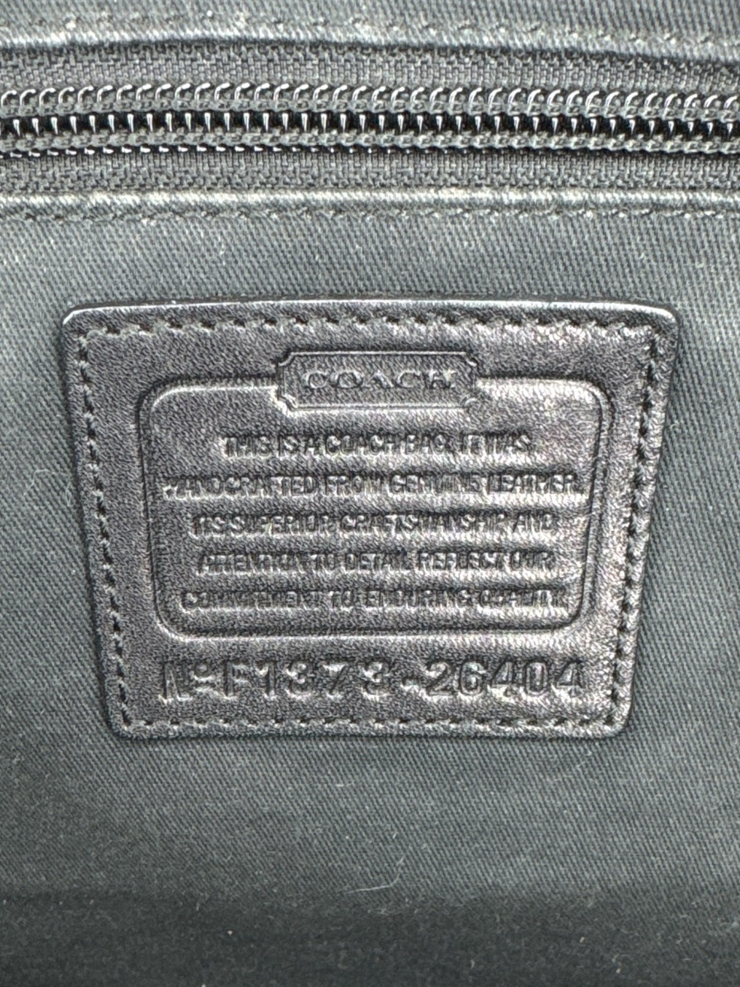 Coach black leather purse with handles, bronze studding, and large leather tassels on front