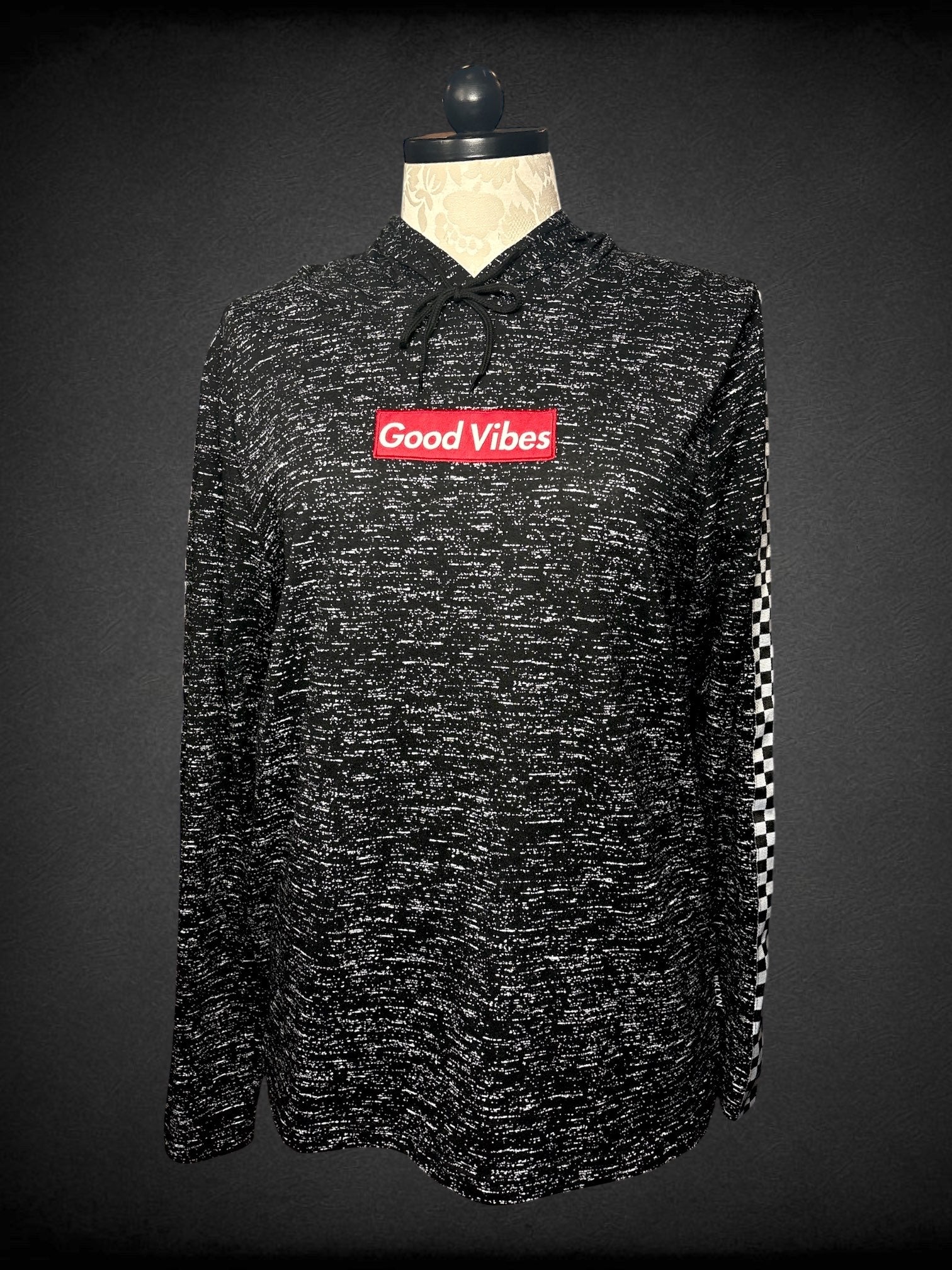 1X Brooklyn Cloth black hooded sweatshirt with white speckling, checker print appliqué on sleeves, and red “Good Vibes” appliqué on front