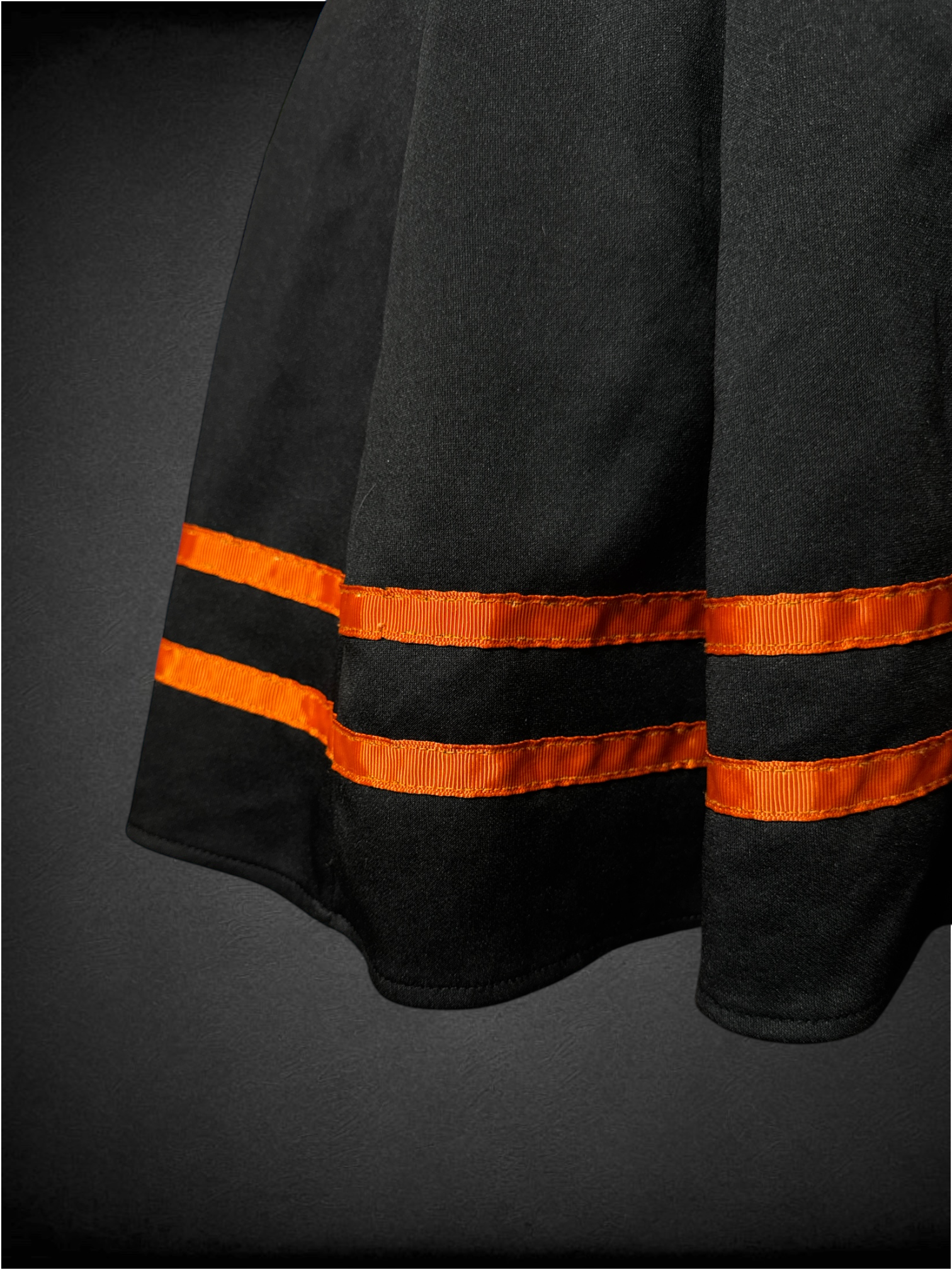 L black pleated skirt with orange ribbon stripes