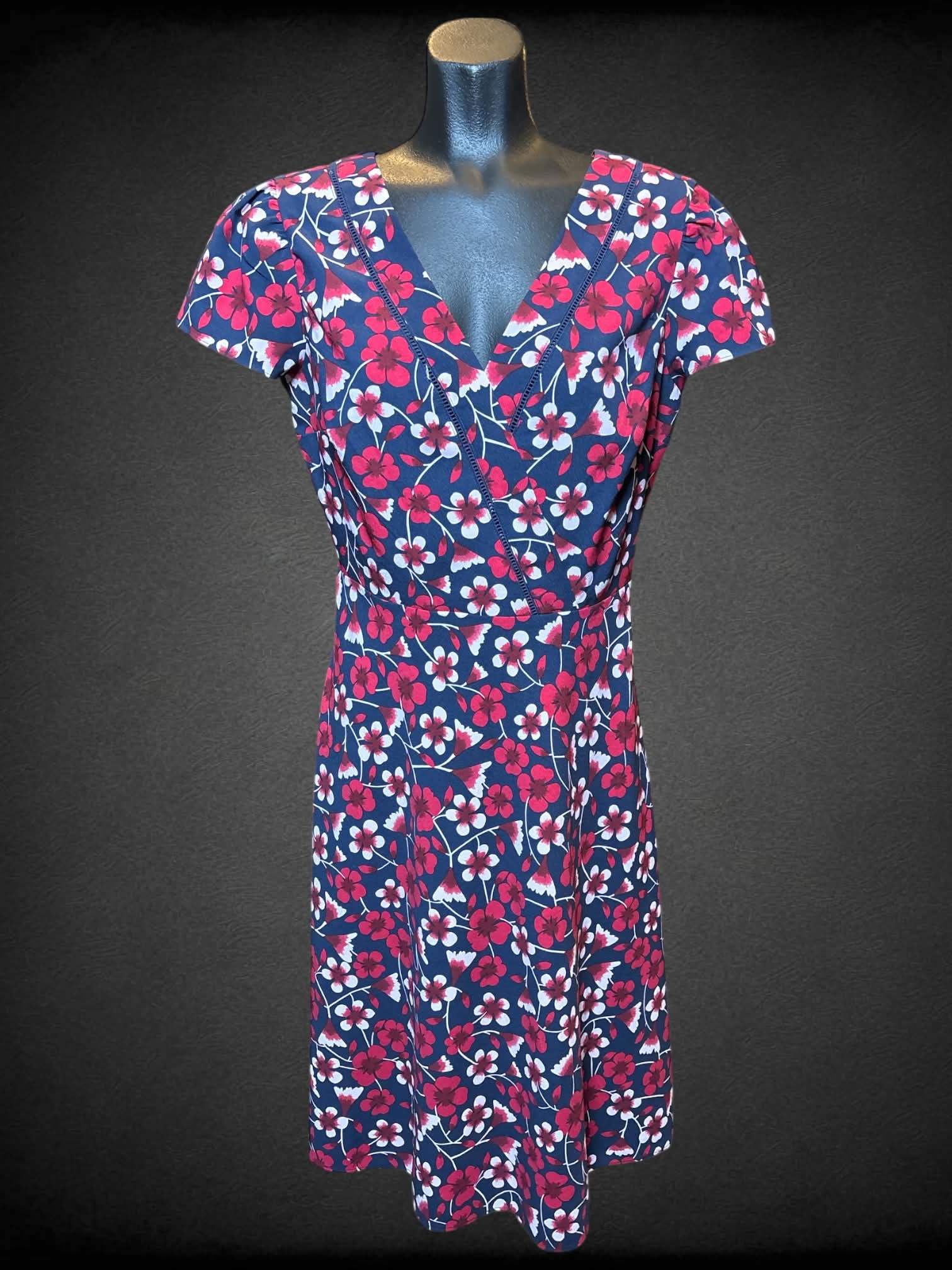 S Draper James navy blue short sleeve dress with pink floral design, zipper on back, and faux wrap design