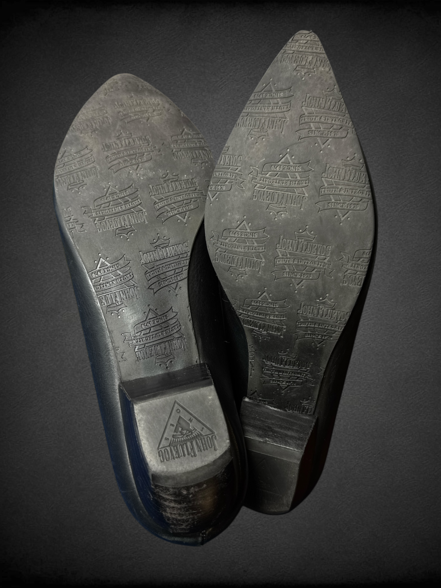 Size 7.5 John Fluevog Makena slip-on shoes featuring a pointed toe, a large metal ring, and stud detailing and dust bag included