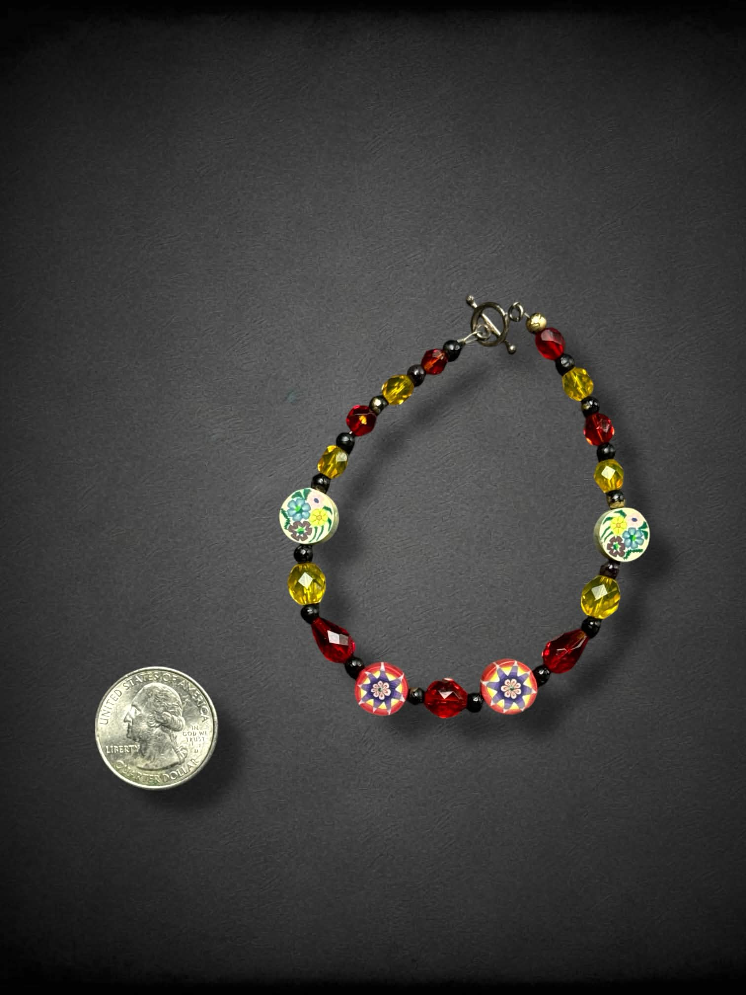 Red, black, and yellow bracelet with floral clay-cane beads