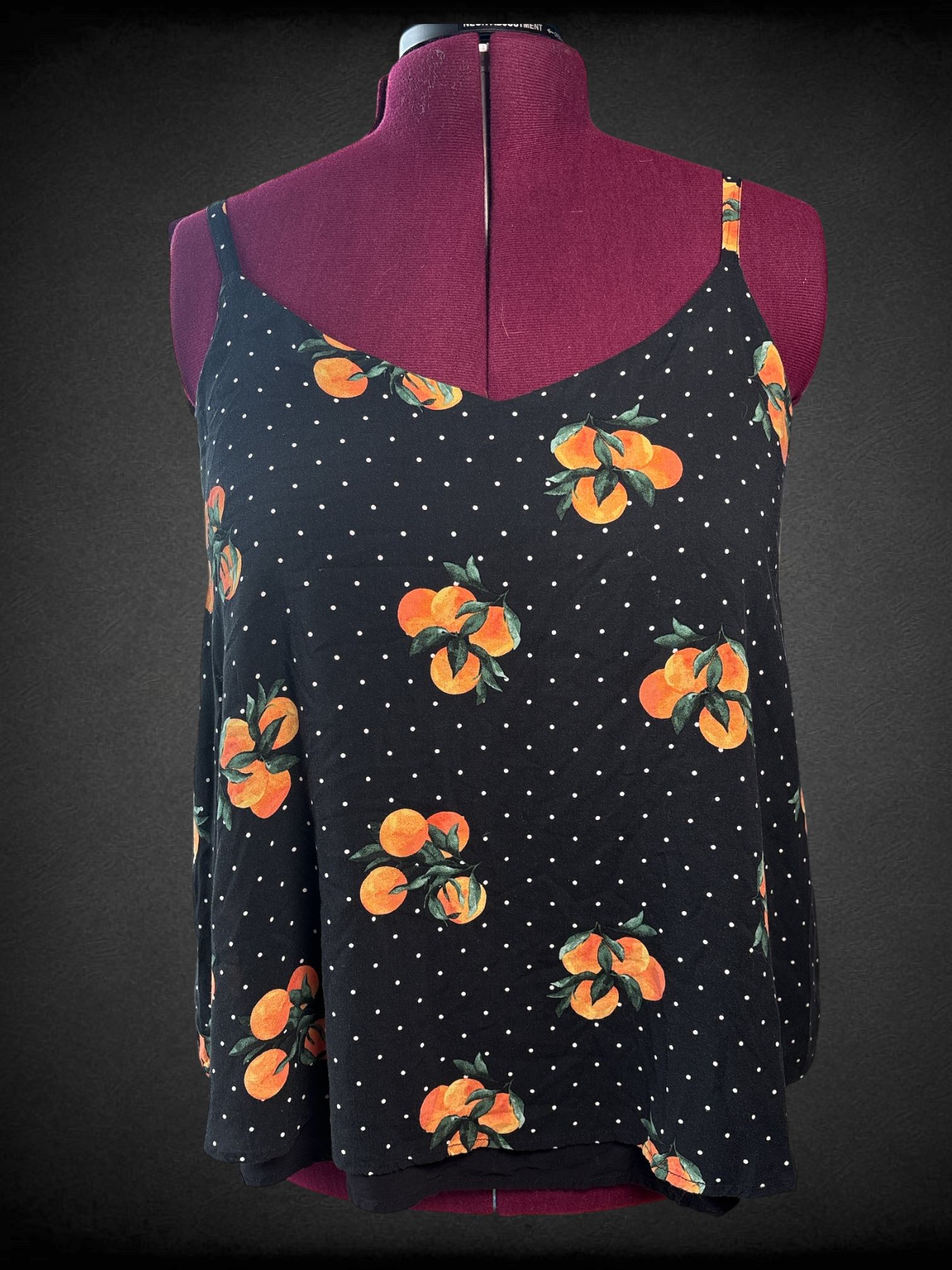 1X Torrid black v-neck tank top with white polka dots and bundles of leafy oranges, adjustable straps, and black longer lining