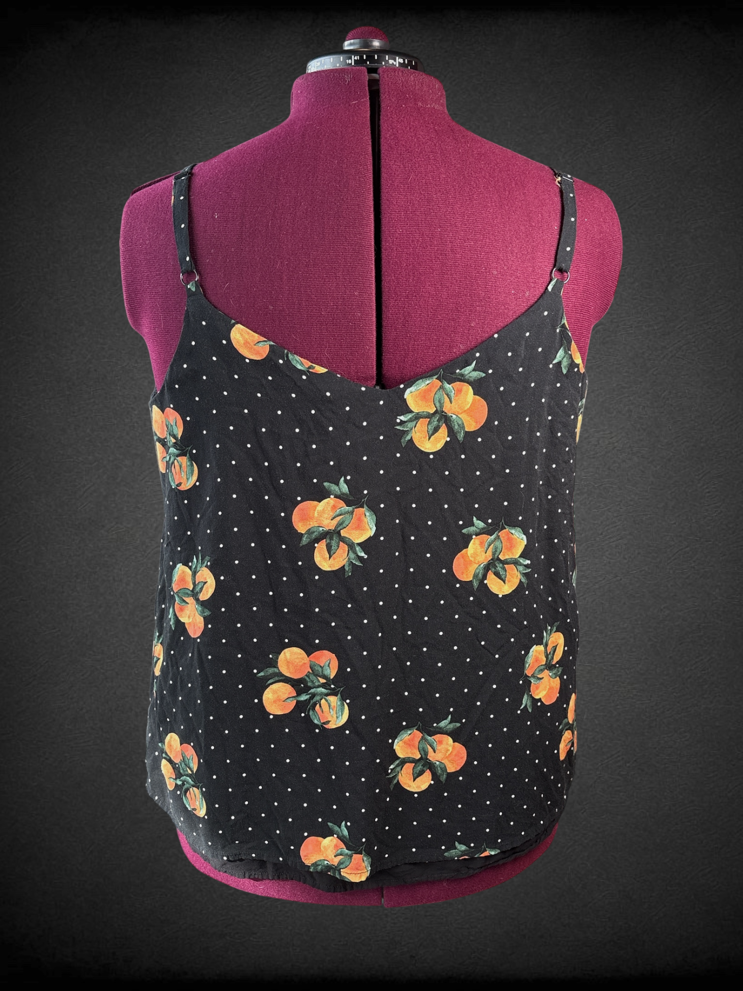1X Torrid black v-neck tank top with white polka dots and bundles of leafy oranges, adjustable straps, and black longer lining
