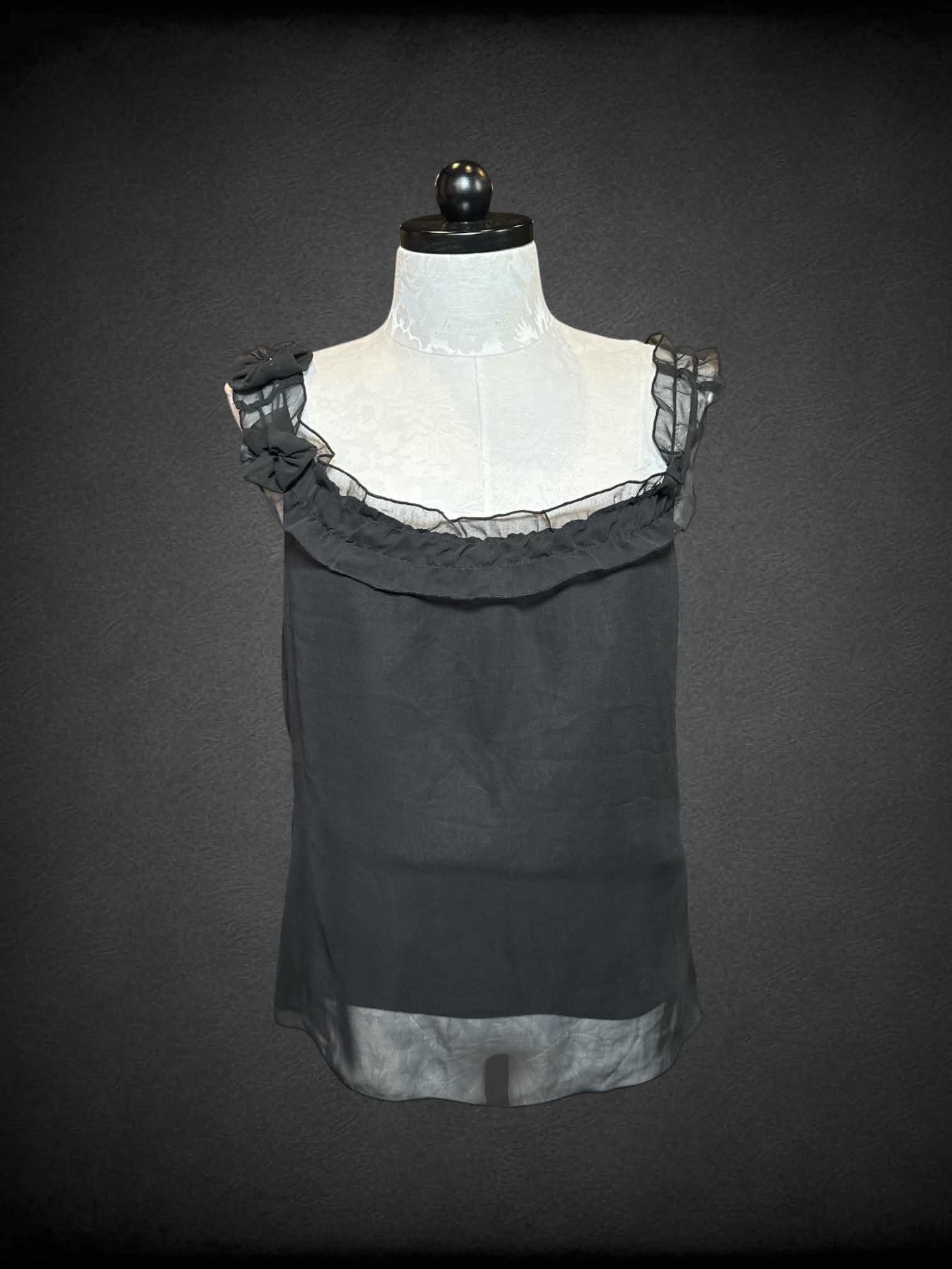 XL Pink Mode black sleeveless sheer top with lining, floral design on one strap, and ruffled neckline