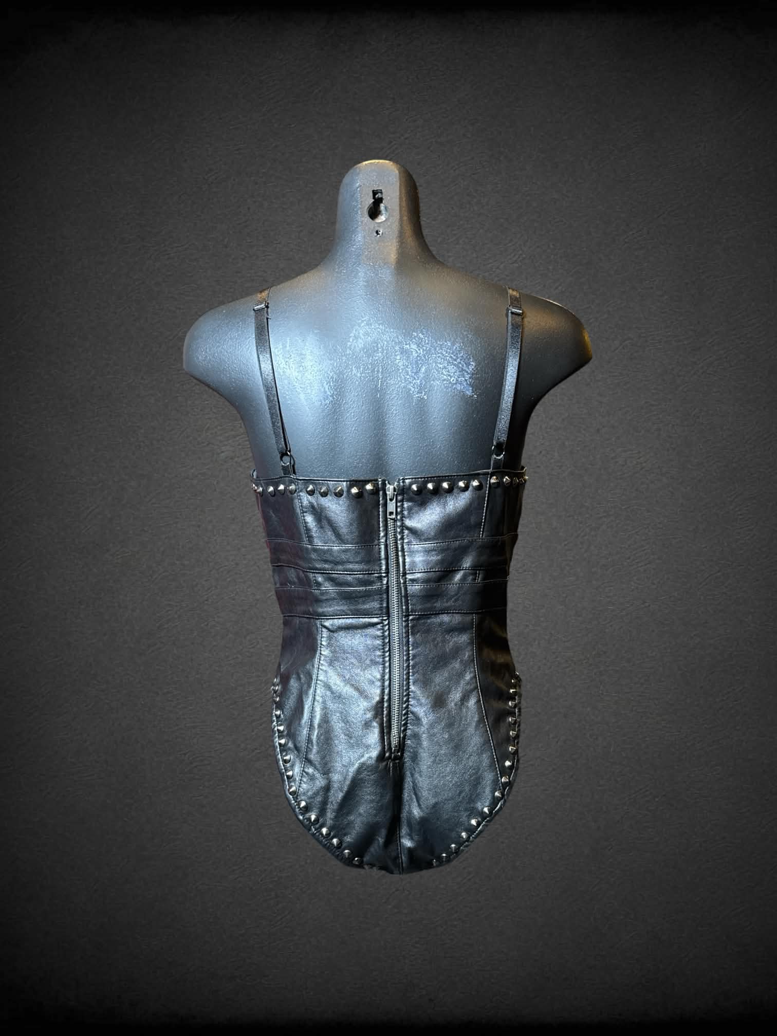 M Club Exx black leather body suit with studs, zipper on back, and buckles on front
