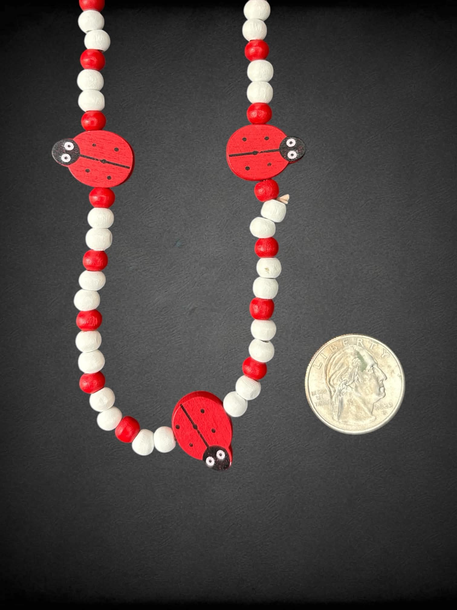Red & white wooden bead necklace with ladybugs