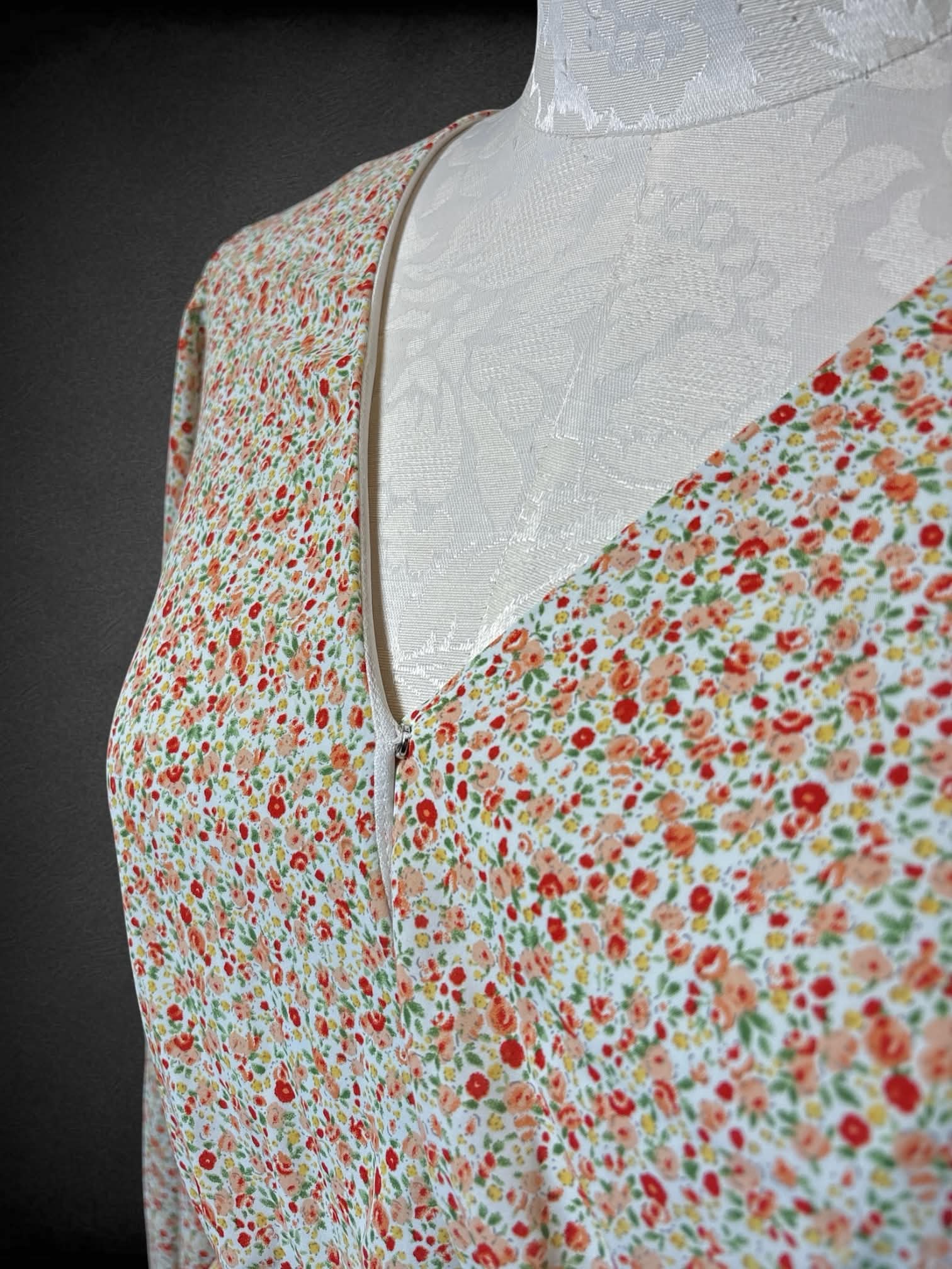 0X Arula white flowy top with pink and red floral pattern, and adjustable tie on waist