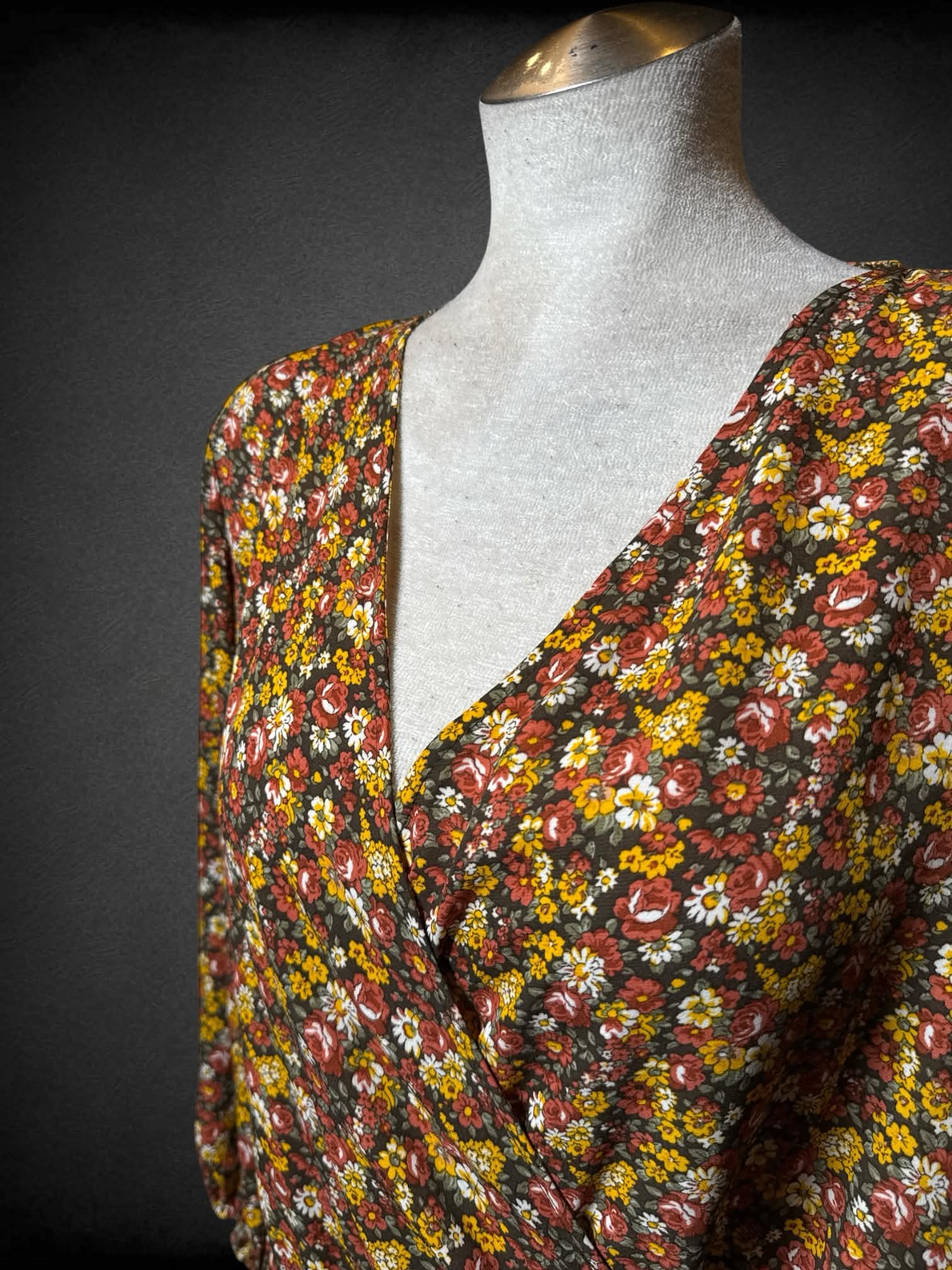 L New York Company brown jumpsuit with yellow & red floral pattern, asymmetrical neck line, and pockets