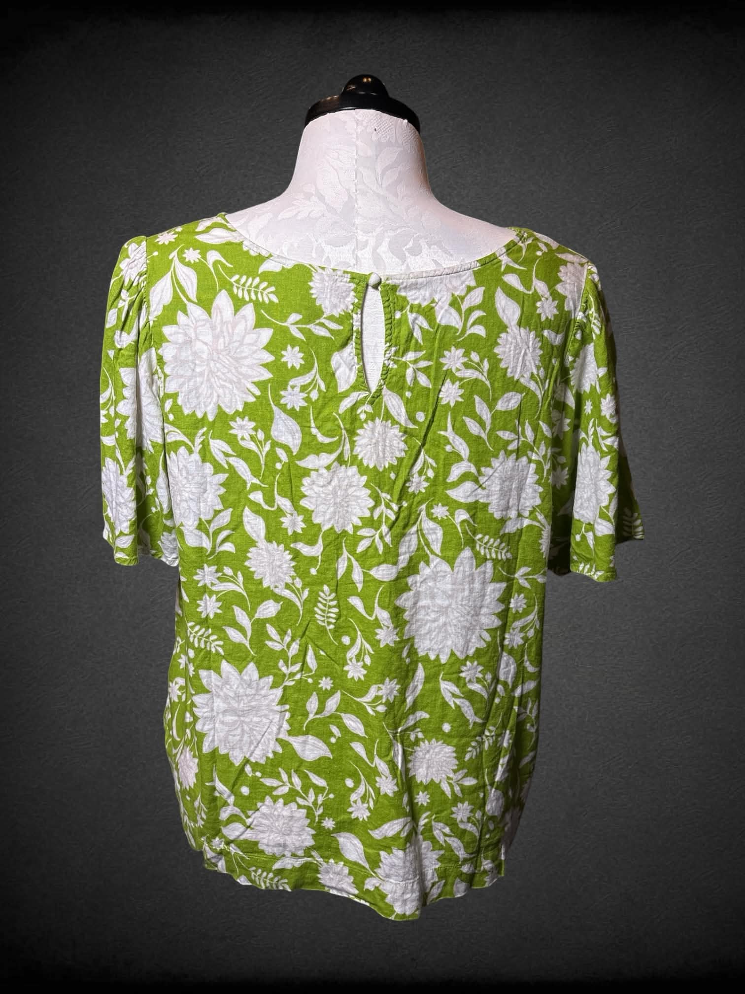 1X Ava Viv green flowy v neck shirt with white floral pattern, and button on back