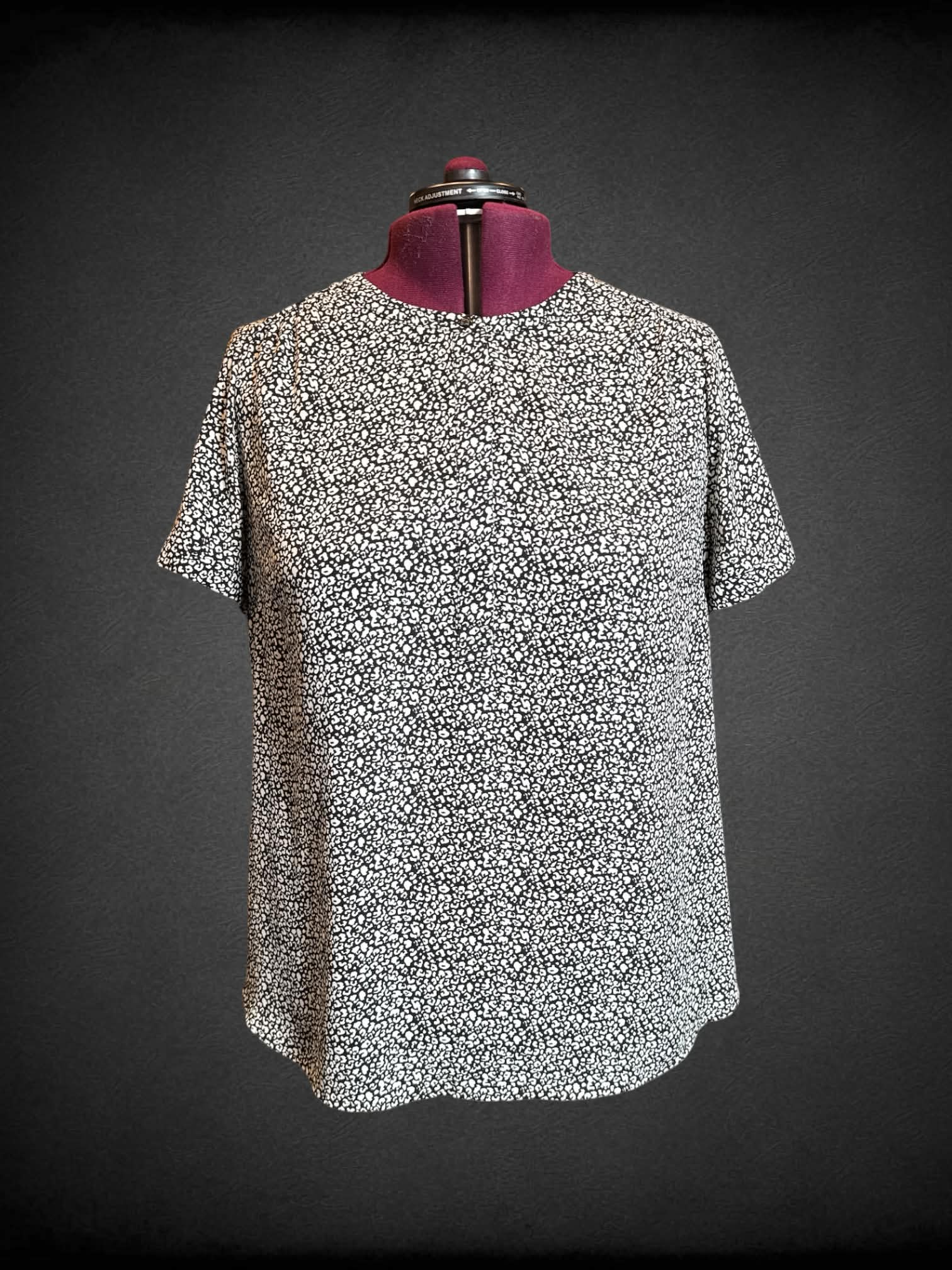 2X Evri black and white leopard print short sleeve top with covered buttons on top