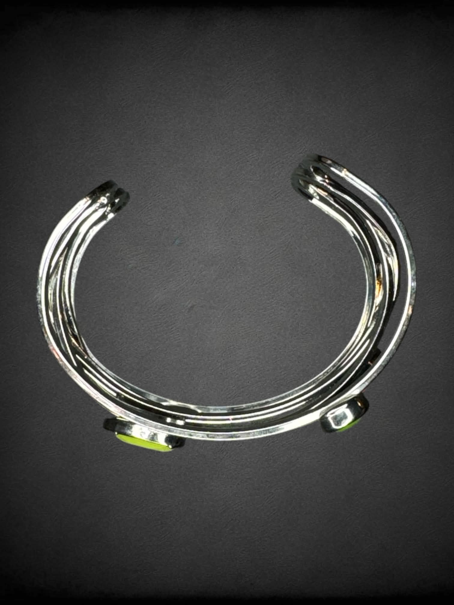 Silver bangle bracelet with green and pink gems