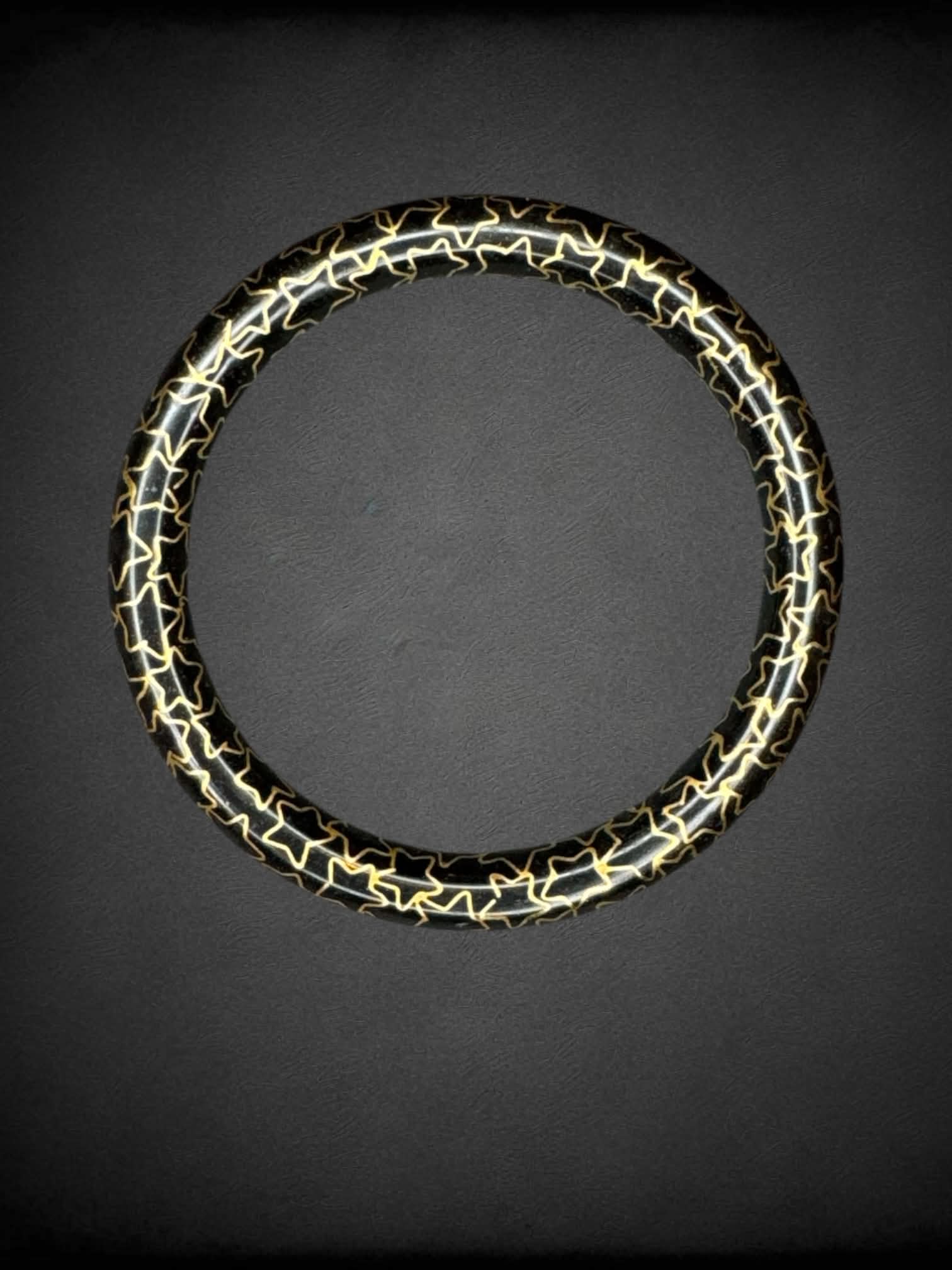 Black bangle bracelet with gold star pattern
