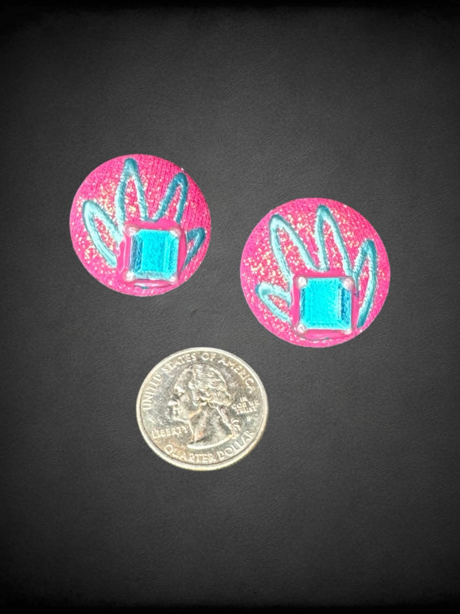 Sparkly pink circular earrings with blue gem