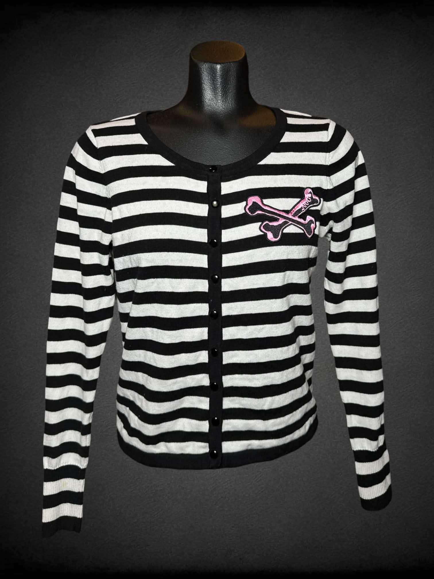 M Too Fast black & white button-up sweater with pink embroidered cross bones on front, and pink skull graphic on back