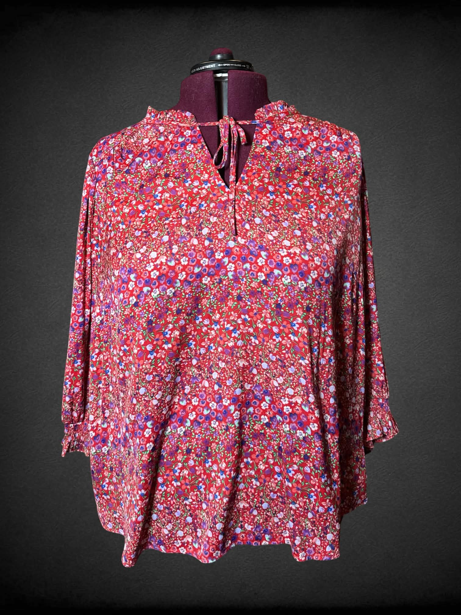 3X Carolina Belle red flowy blouse with colorful floral pattern, and adjustable tie on neck