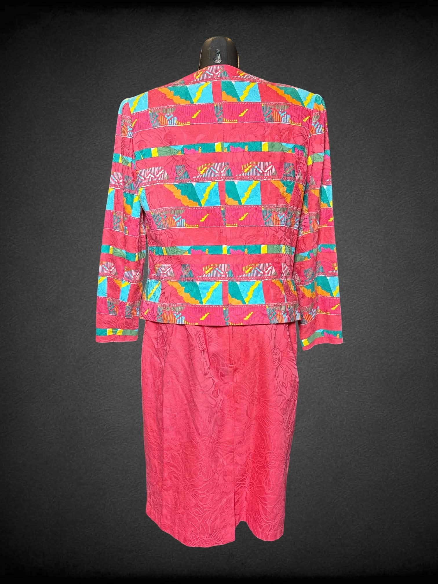 M Anne Crimmins For Umi Collections vintage two-piece set: hot pink blazer with padded shoulders, colorful pattern and buttons on front. Skirt has embroidered flower pattern, zipper and button on back