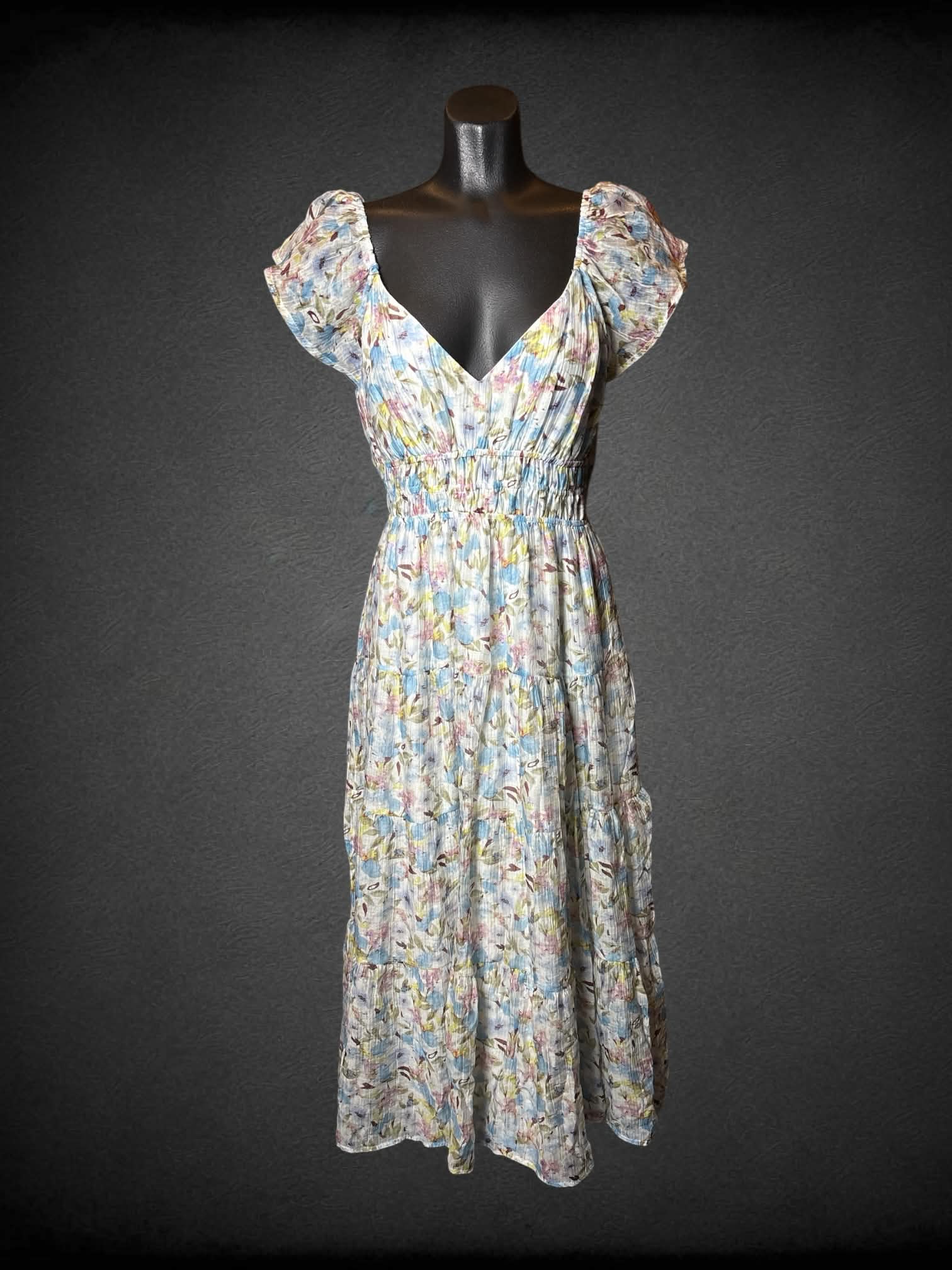 M Storia white flowy sundress with pastel floral design, cutout on back, and shirred waist