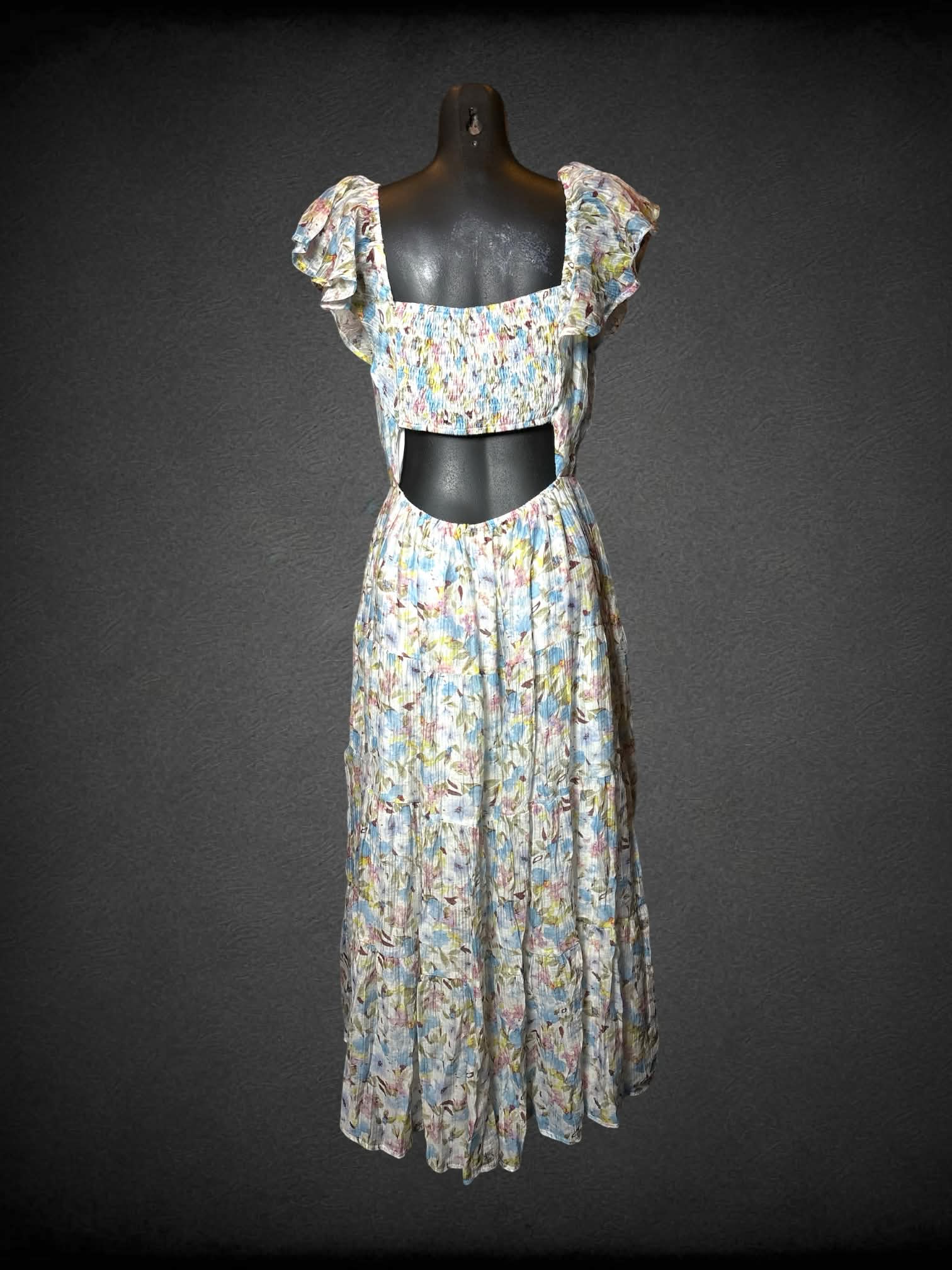 M Storia white flowy sundress with pastel floral design, cutout on back, and shirred waist
