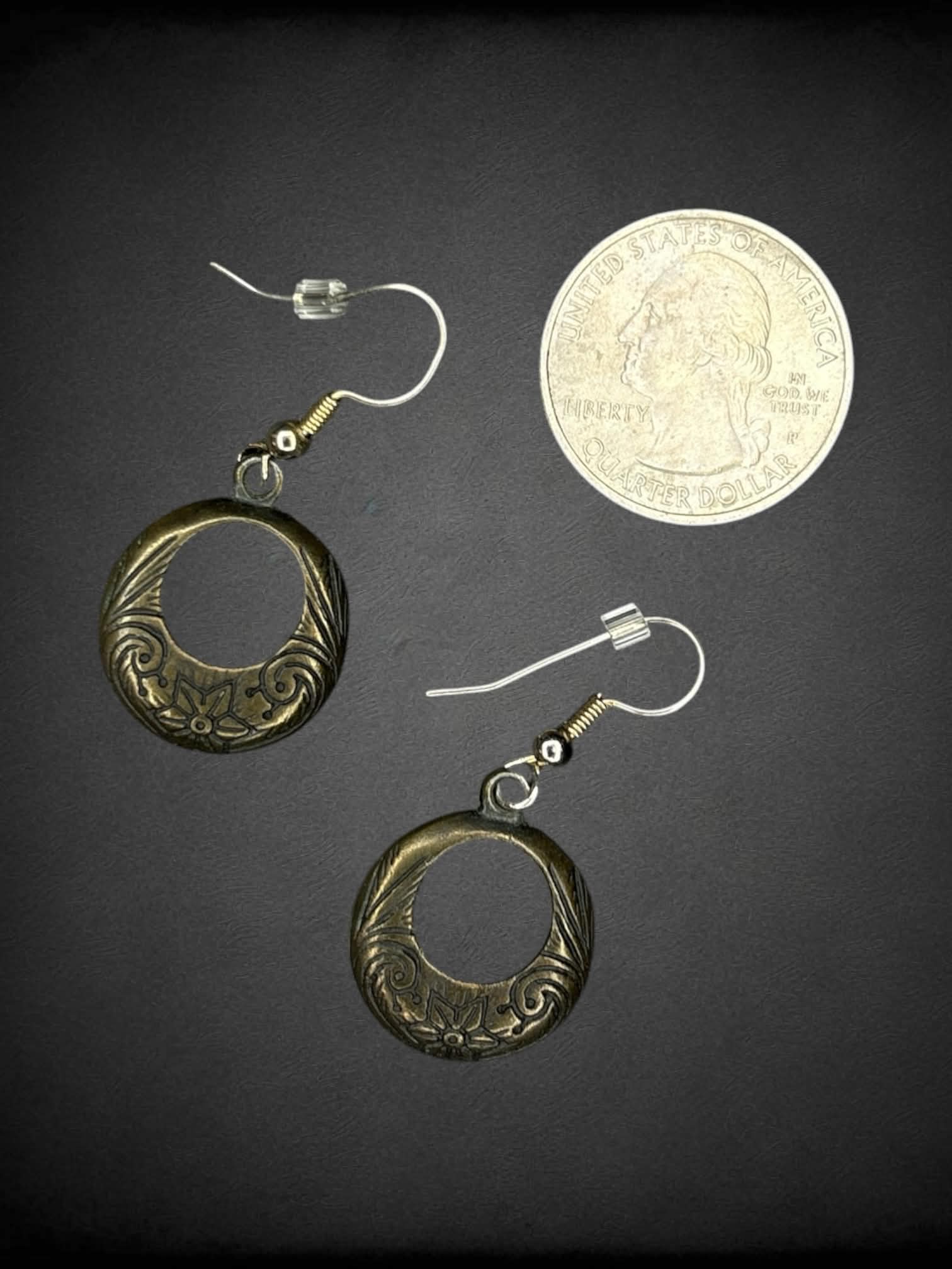 Circular metallic earrings with floral engravings