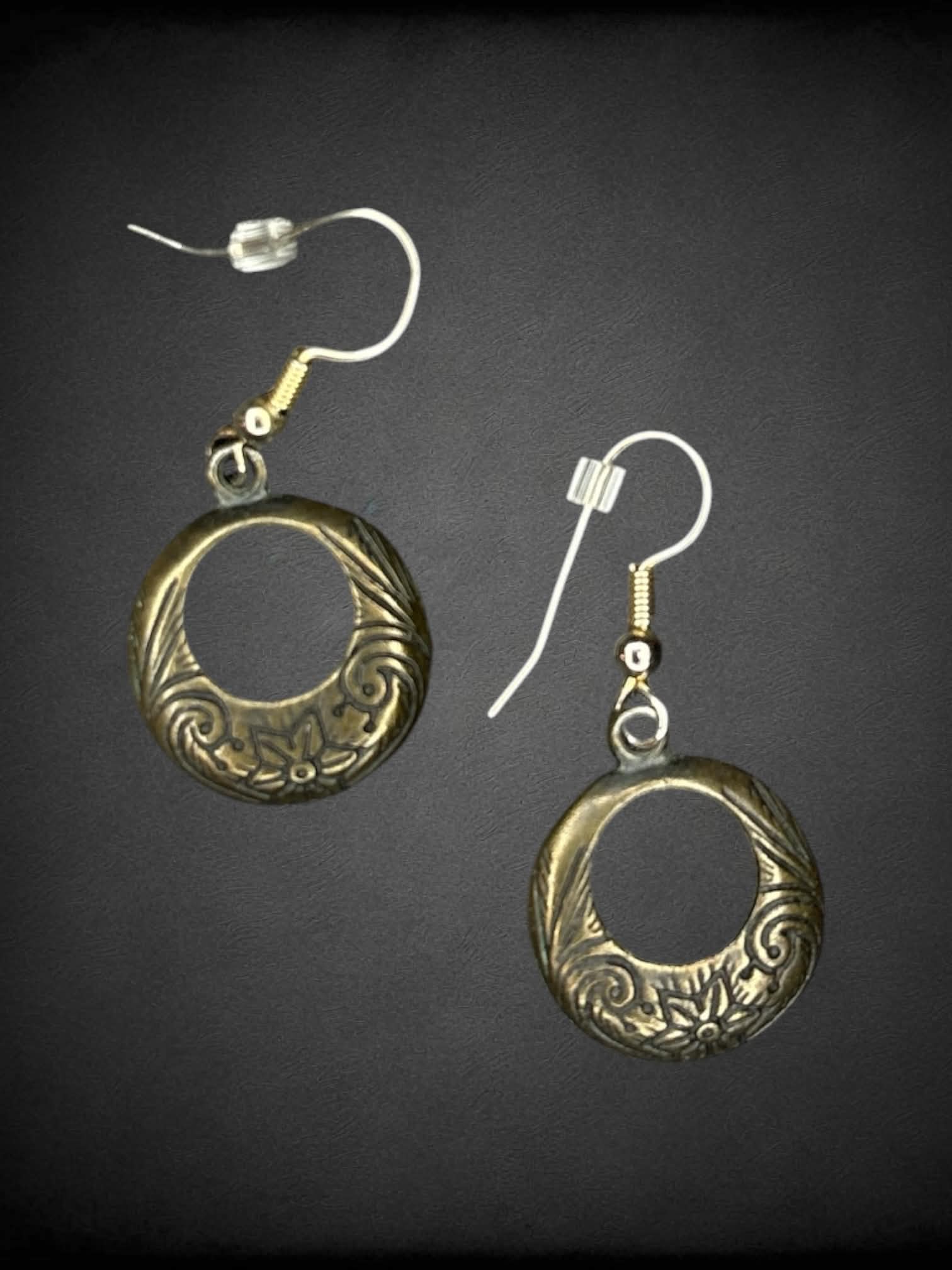 Circular metallic earrings with floral engravings