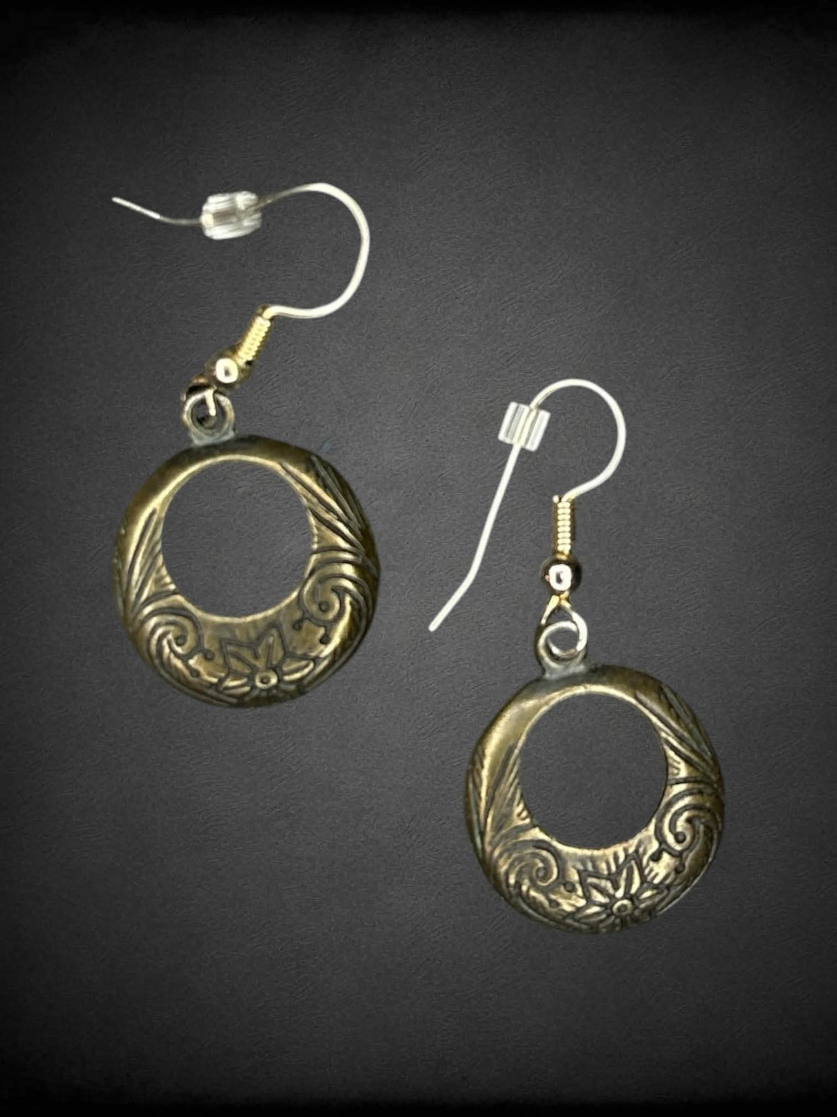 Circular metallic earrings with floral engravings