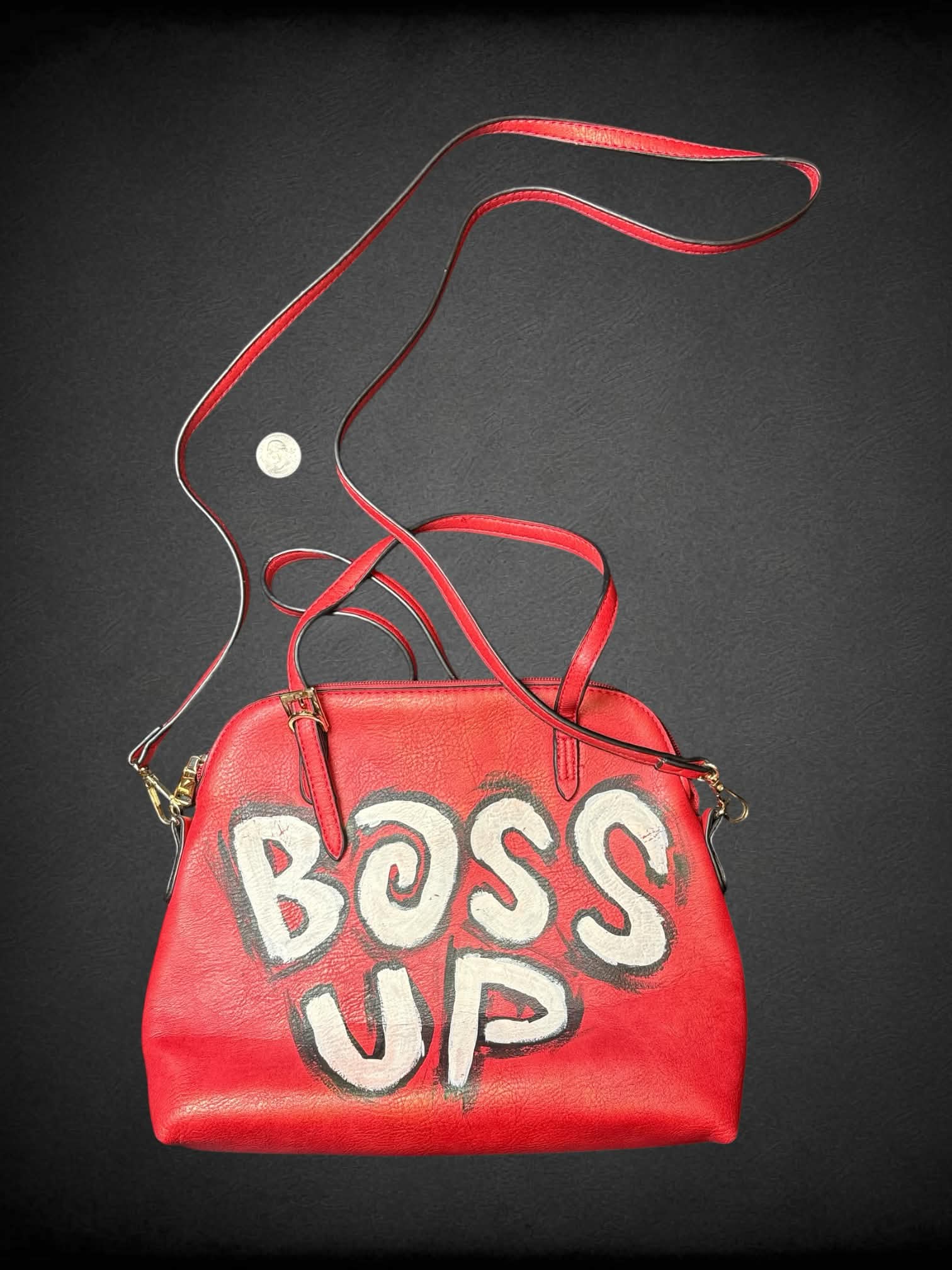 Red faux leather shoulder bag with hand-painted “Boss Up” writing on front