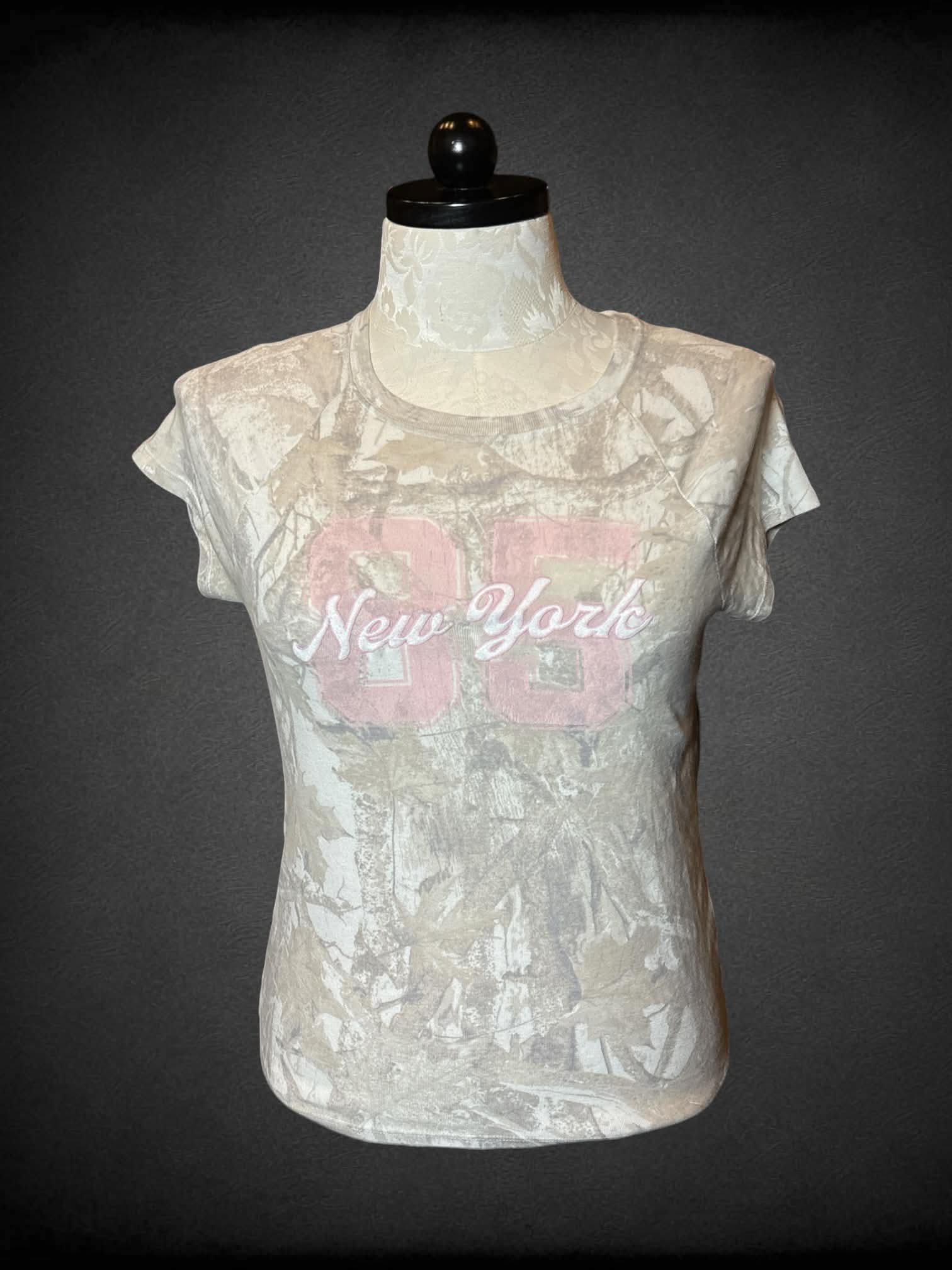 XL Hollister off-white nature camo baby tee with embroidered “New York” and number 85 on front