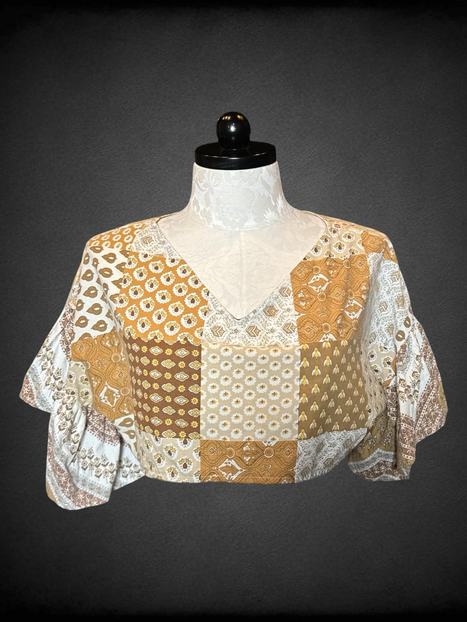 1X brown cropped top with “quilt-like” design, and ruffle bell sleeves