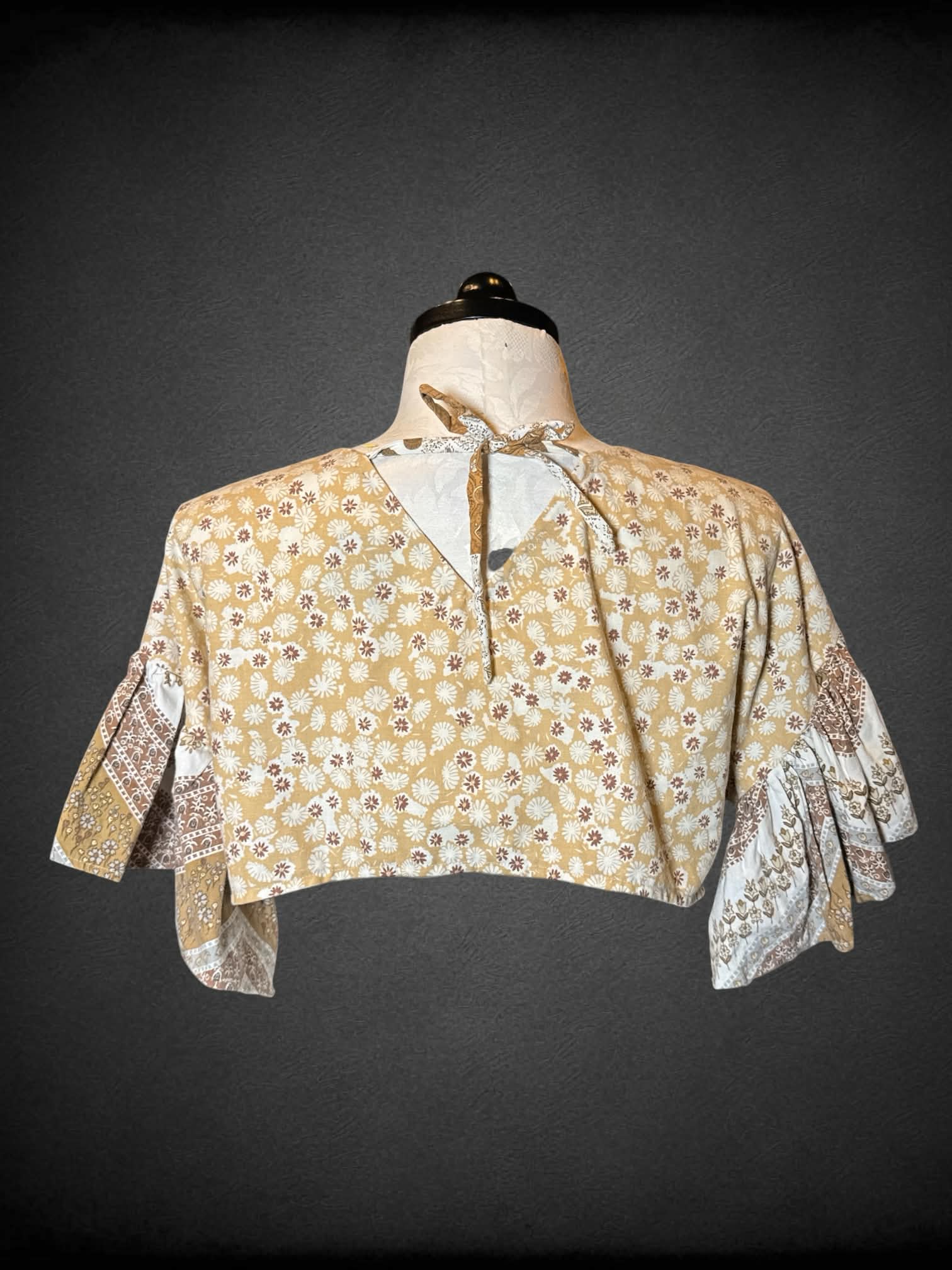 1X brown cropped top with “quilt-like” design, and ruffle bell sleeves