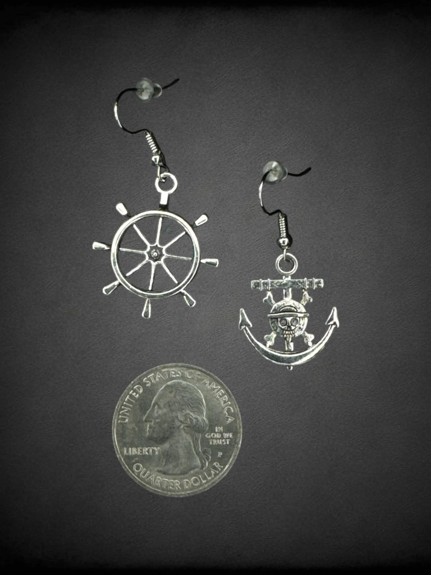 Silver earrings from “One Piece” featuring pirate ship wheel and anchor charms