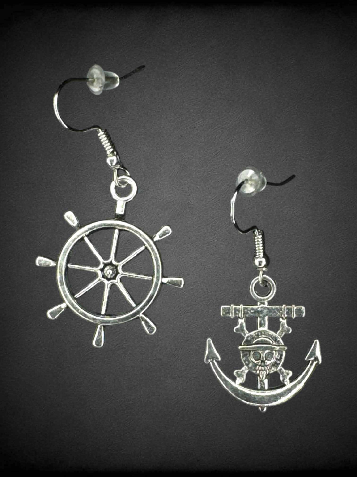 Silver earrings from “One Piece” featuring pirate ship wheel and anchor charms