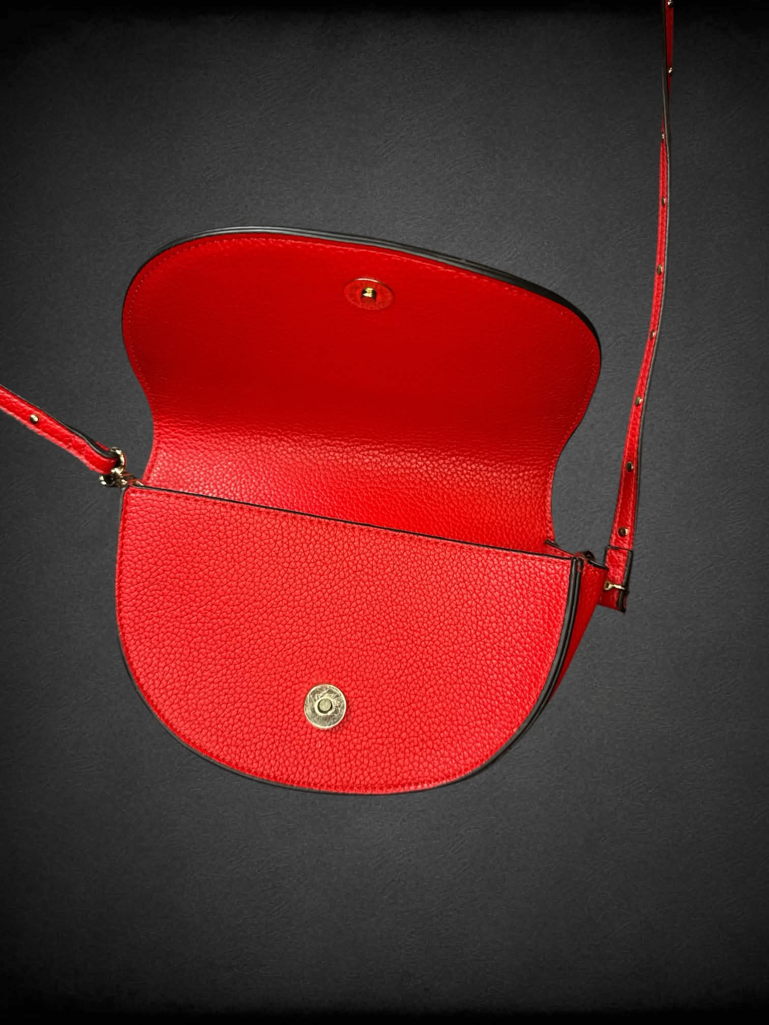Steve Madden red textured faux leather shoulder bag with studded strap, and snap button pocket