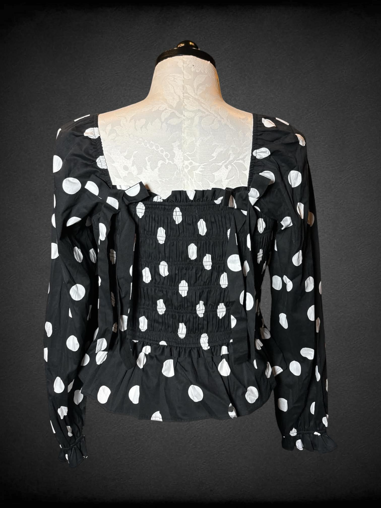 0X Francesca’s NWT black long-sleeve blouse with shirred top, white polka dot pattern, and decorative bows on back