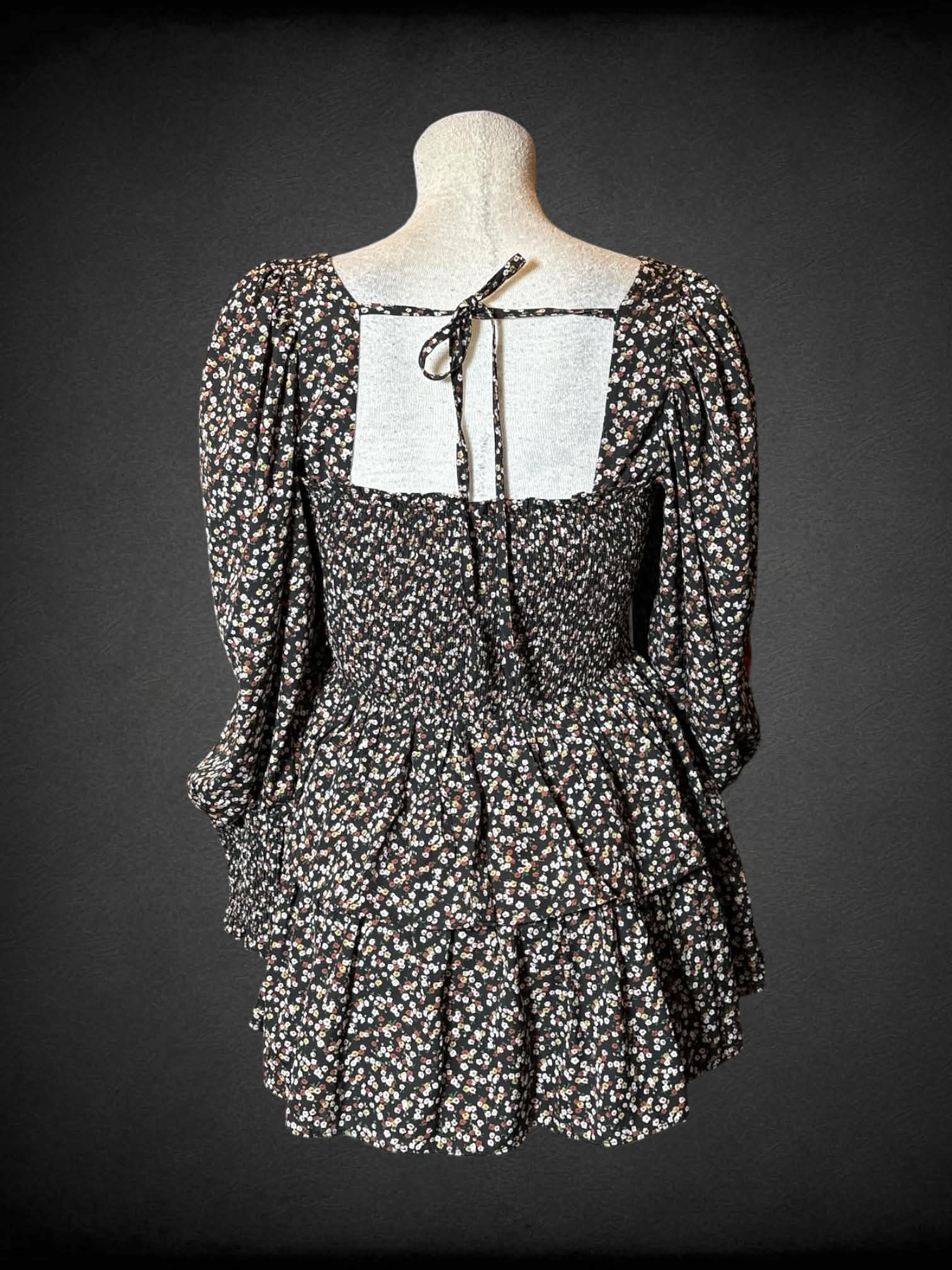 L Byinns black long-sleeve short dress with floral pattern, shirred top, ruffled design on skirt, and cutout on back